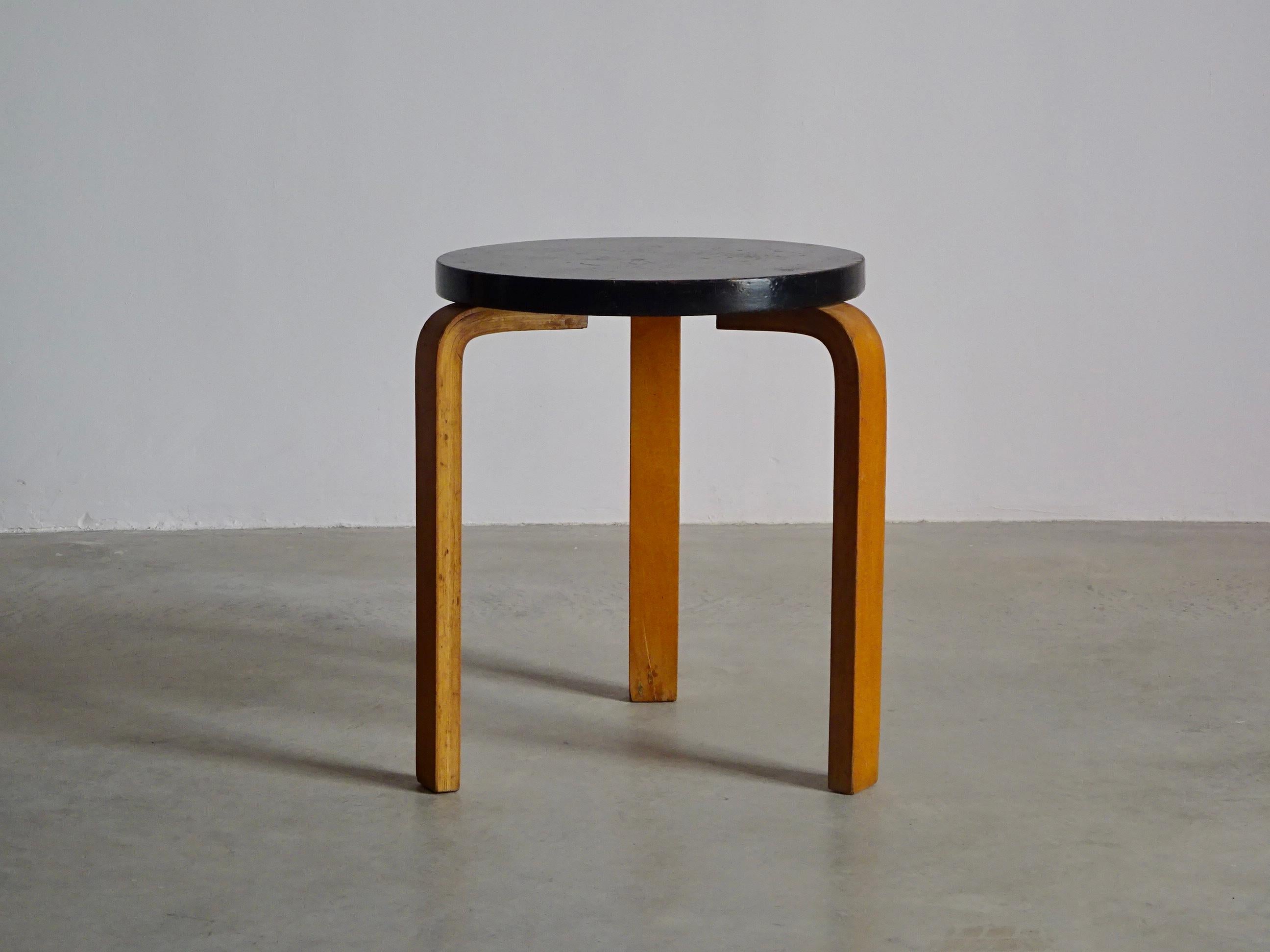 Stool 60 designed by Alvar Aalto, unknown producer. Strong structure in curved plywood legs and black painted wood seat, original screws. The stool is ready to use, with the beautiful patina by years.
 