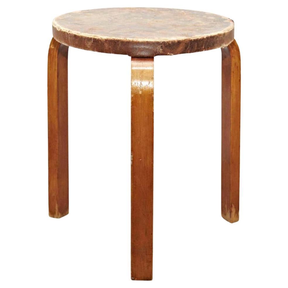 Stool designed by Alvar Aalto, circa 1960.
Manufactured by Artek, (Finland)
Leather top, wood legs and structure.

In great original condition, with minor wear consistent with age and use in the structure some broken leather top, preserving a