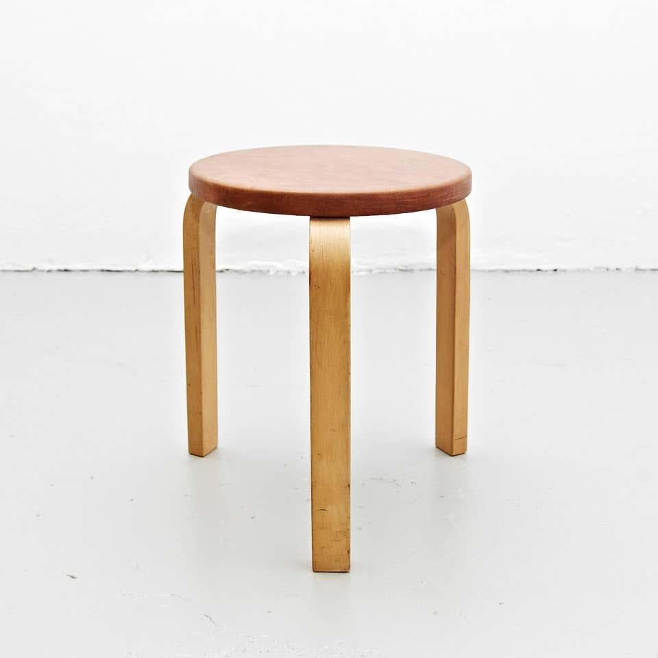 Stool designed by Alvar Aalto, circa 1960.
Manufactured by Artek (Finland).
New leather top, wood legs and structure.

In great original condition, with minor wear consistent with age and use, preserving a beautiful patina.

Hugo Alvar Henrik