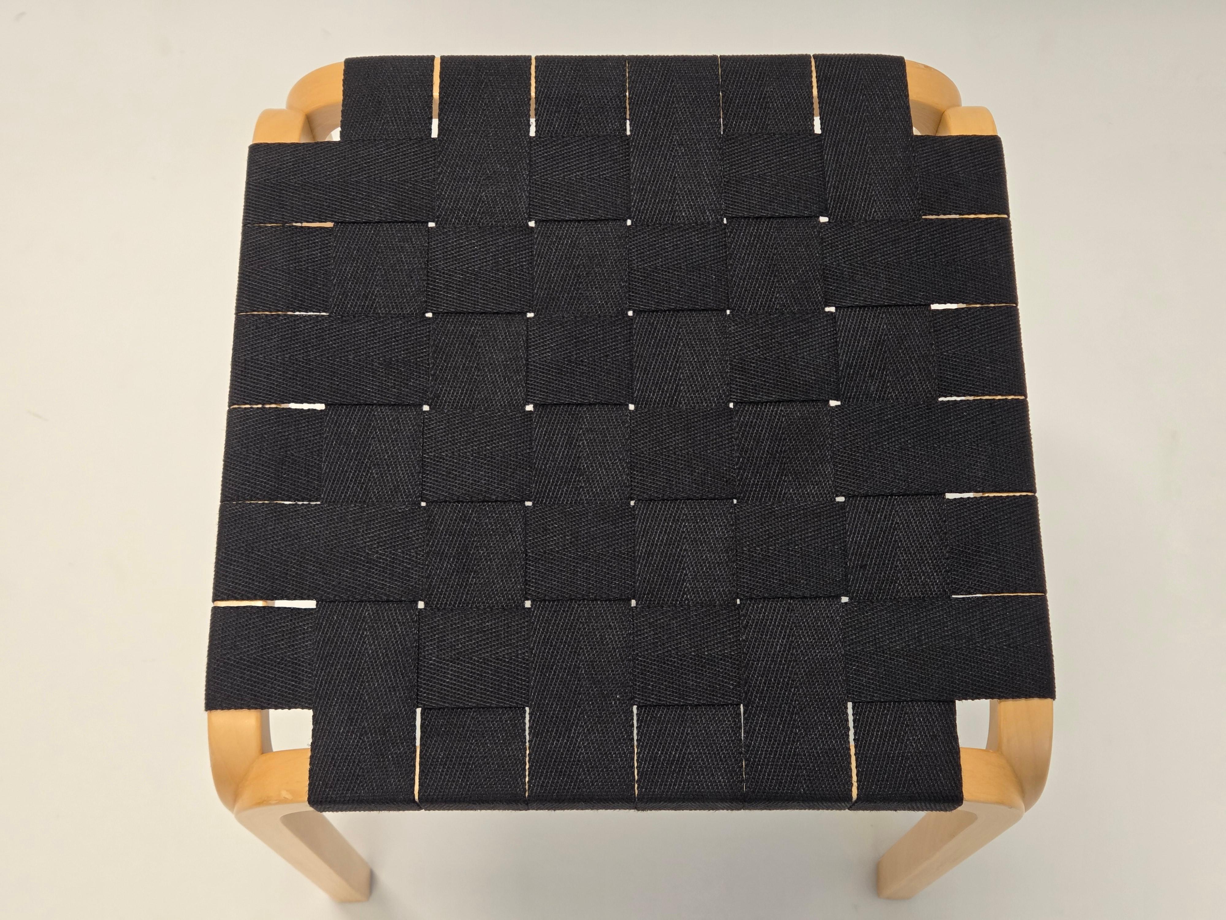 Artek's model Y61 stool, birch with black saddle belts. Designed by Alvar Aalto. In very good used condition. Airy design and beautiful Y-shaped leg structures.