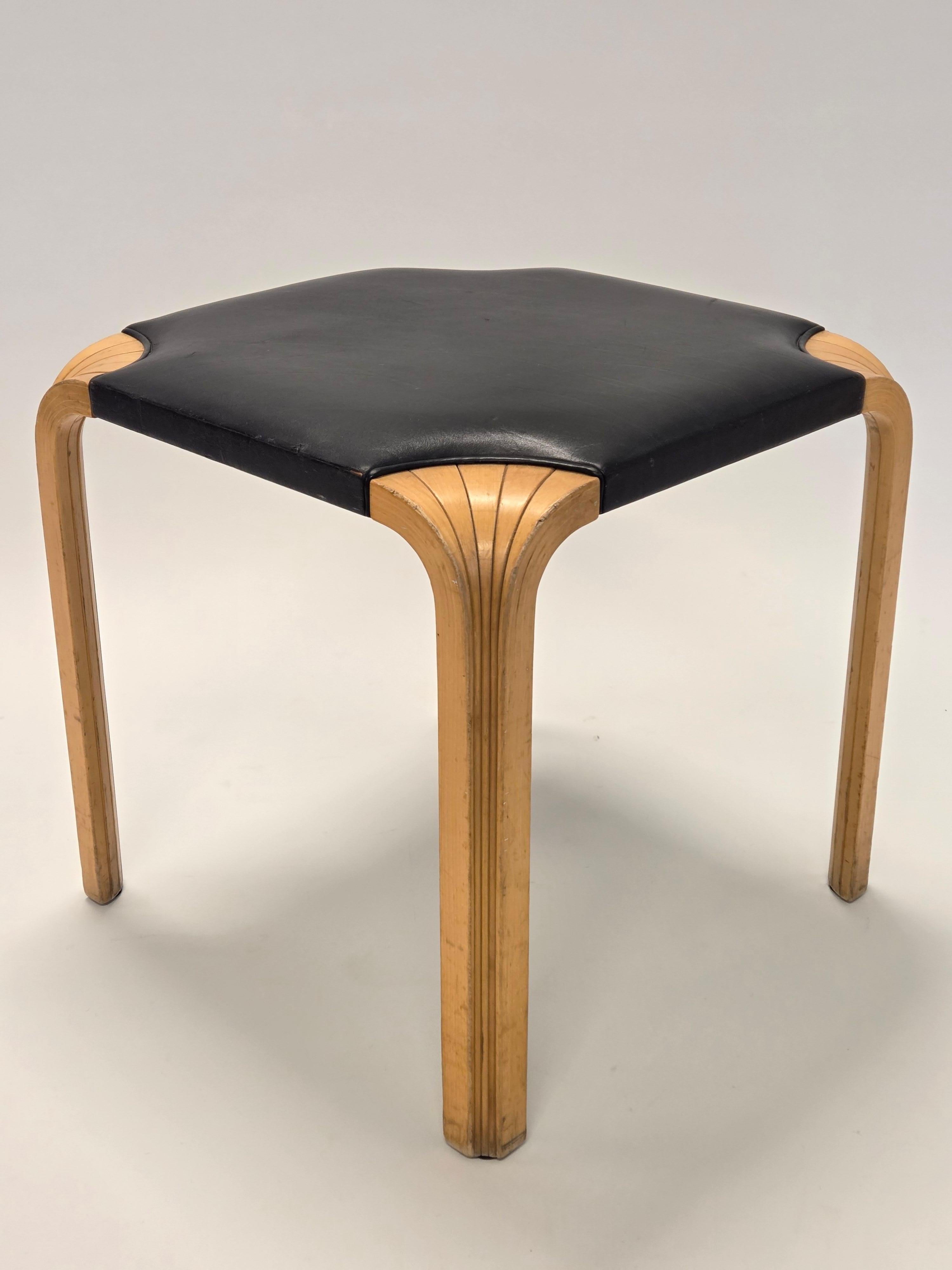 Taburete Artek X601, diseño de Alvar Aalto. Abedul con cuero negro, patas de abanico, maravillosa pátina del tiempo. En buen estado para su edad. 

El taburete Artek X601, diseñado por Alvar Aalto en 1954, es un ejemplo clásico de su diseño de