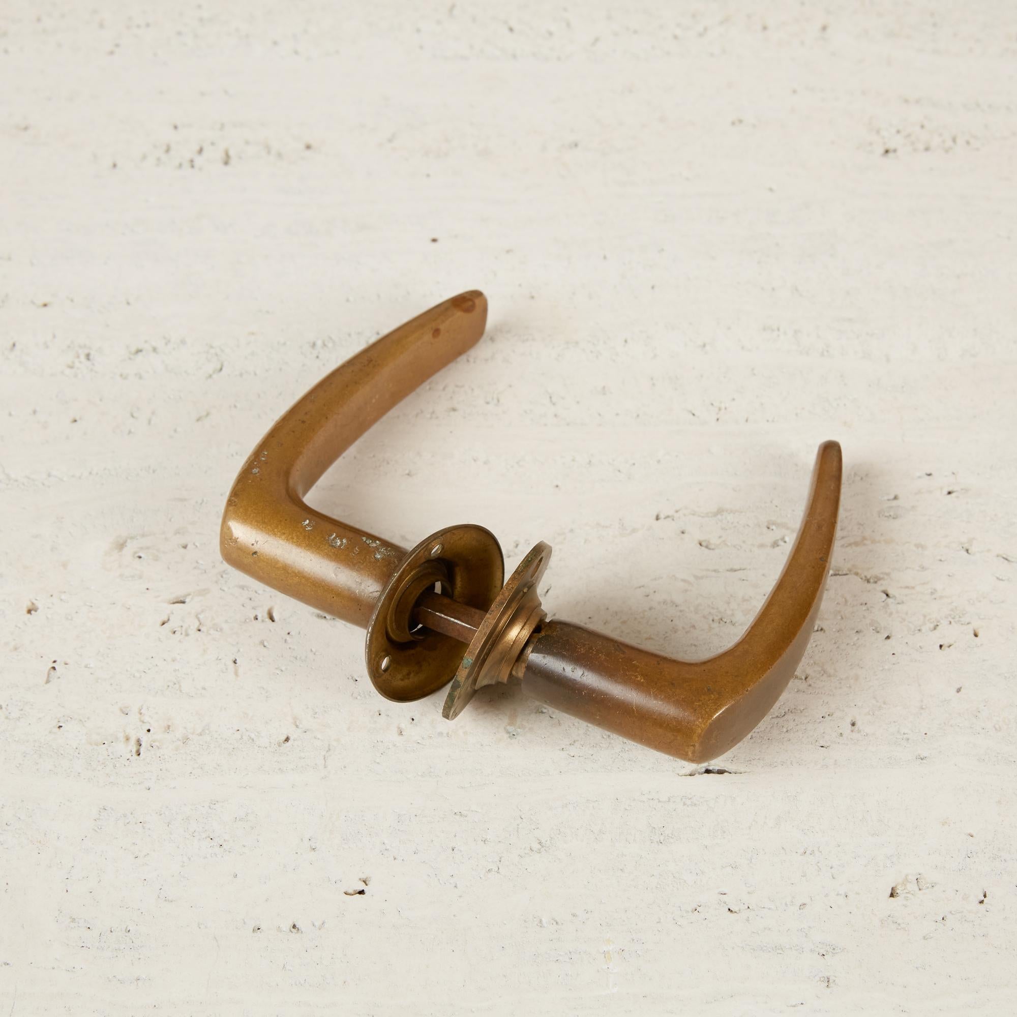 These weighty Alvar Aalto style solid bronze door handles with matching mounting plates make you feel like you’re entering a space with purpose. With minor patination, these still retain a lot of their original golden color, and are cold and