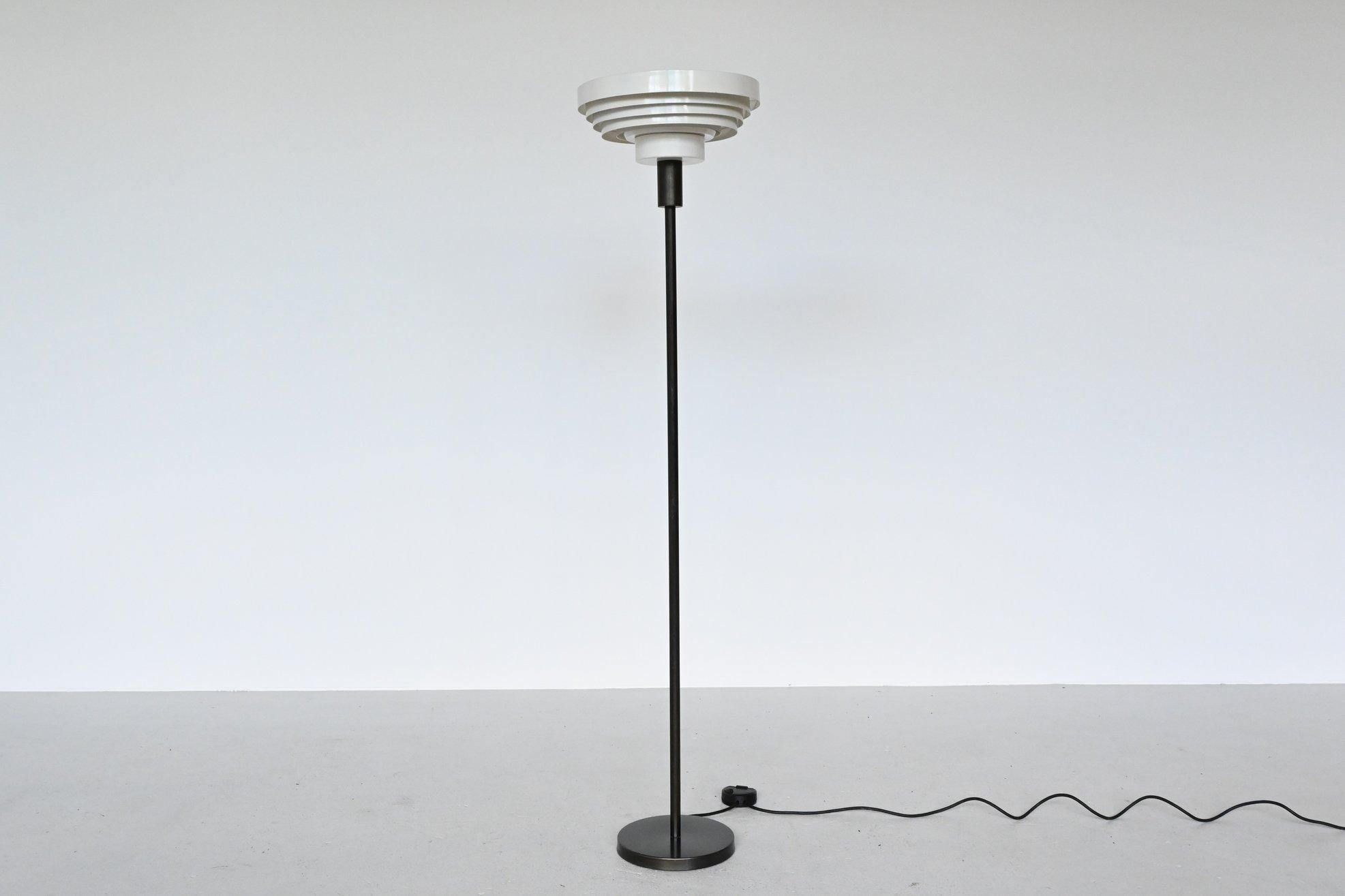 Impressive floor lamp designed in the style of Alvar Aalto, Denmark, 1960. This lamp has a very dark grey ebonized bronze foot and white lacquered aluminium shade. The lamp gives very nice warm diffused light when lit because of the many layers and
