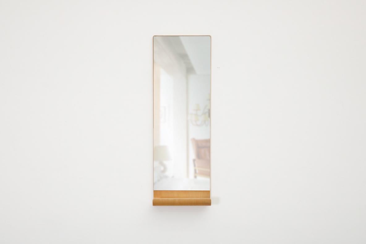Bellissimo specchio rettangolare sospeso olandese di metà secolo, montato a parete. L'incantevole design di questo pezzo è caratterizzato da un utile,  Mensola in legno curvato ispirata ad Alvar Aalto che può essere utilizzata per tenere una