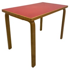 Table Alvar Aalto modèle 81B, surface en linoléum rouge.
