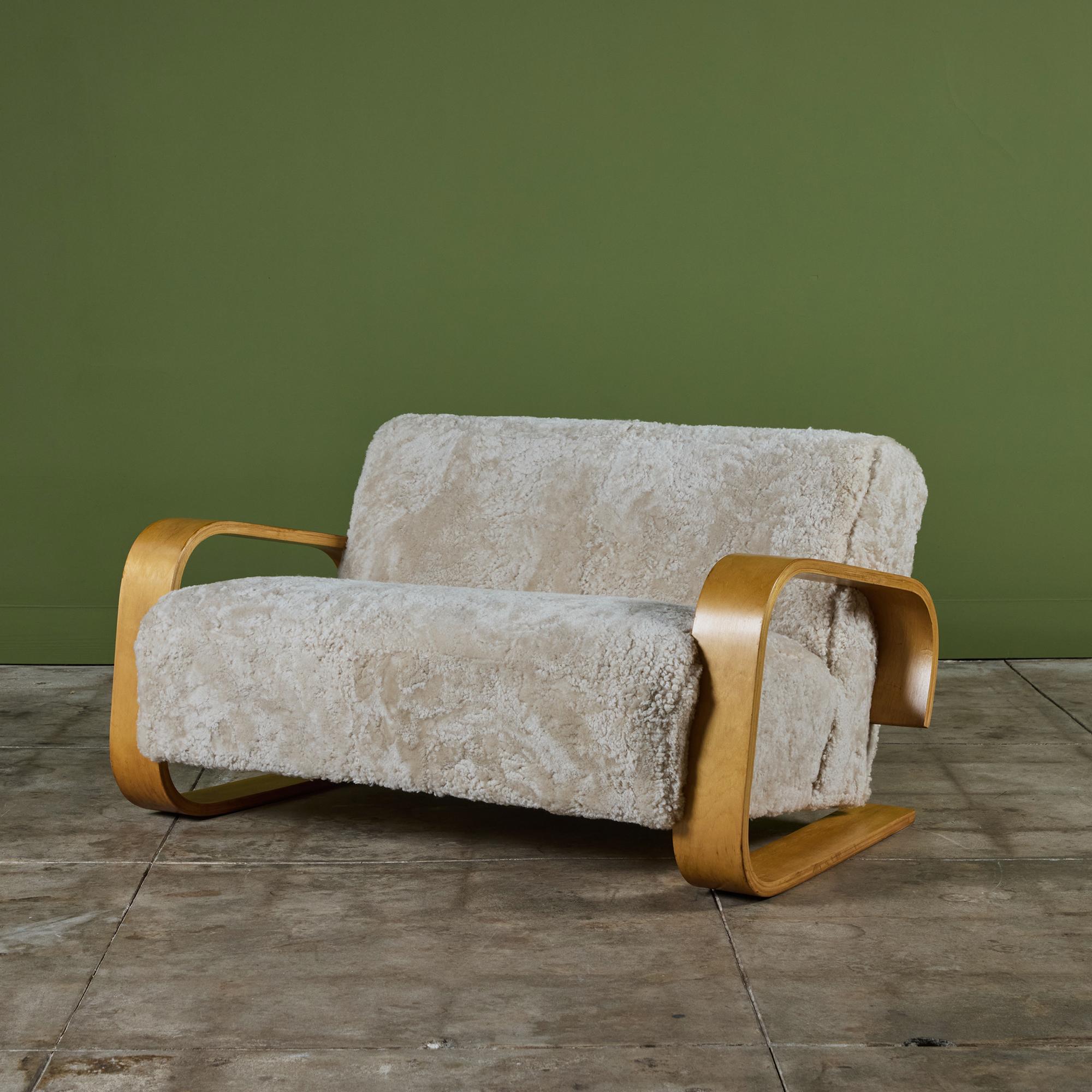 Diseñado por Alvar Aalto y producido por Mouldcraft c.1950s, Canadá. El sofá, también conocido como sofá Tanque, es un diseño poco común que presenta un armazón en voladizo de madera de abedul curvada que confiere al sofá un efecto flotante. El sofá
