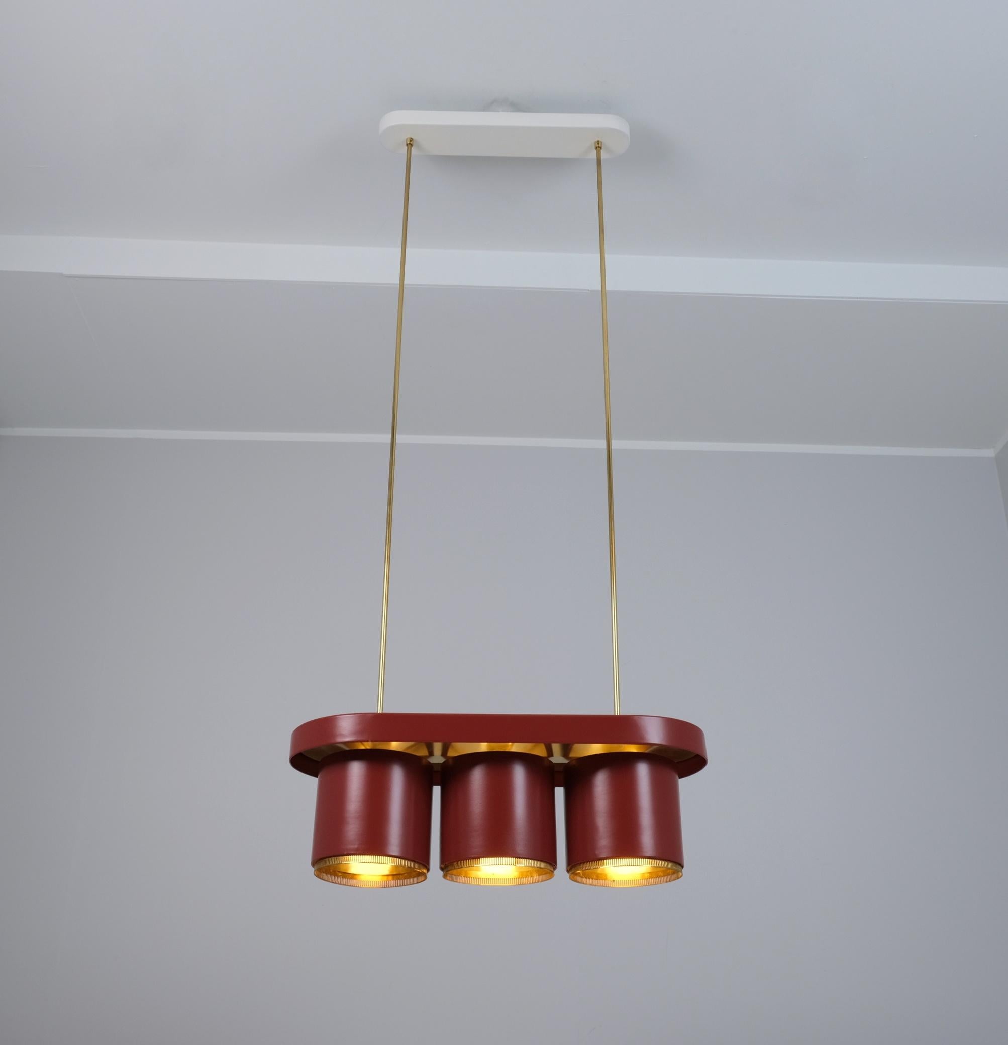 Uno splendido ciondolo di metà secolo di Alvar Aalto in rosso e ottone, prodotto da Aalto+Aalto Finlandia, anni '50. Questa lampada è una delle nostre lampade a sospensione preferite di Alvar Aalto e sembra essere una delle sue, dato che la usava