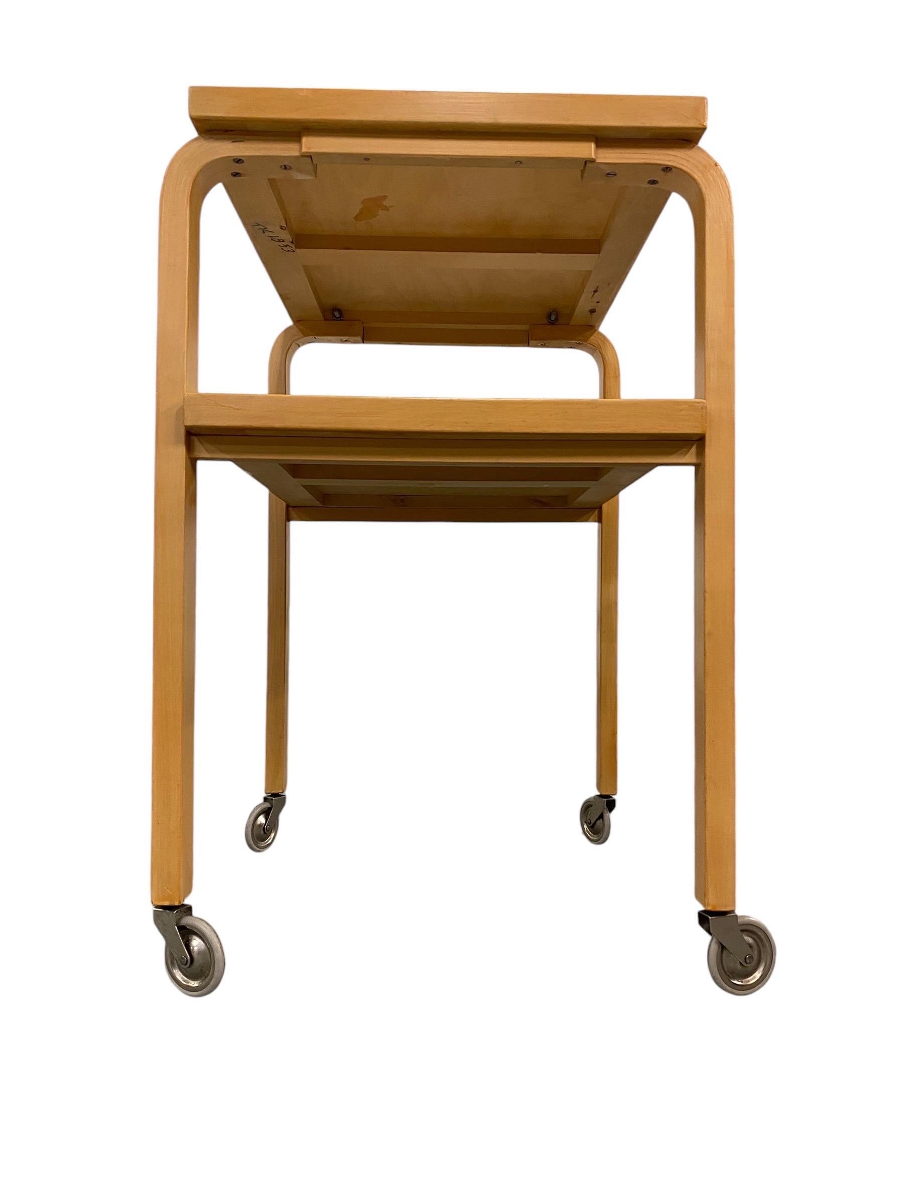 Serving cart/trolley designed by Alvar Aalto and retailed by his company Artek in Finland in the 1960s. This vintage Scandinavian modern serving trolley, features a minimalist yet highly functional design. Crafted with light, natural wood and clean