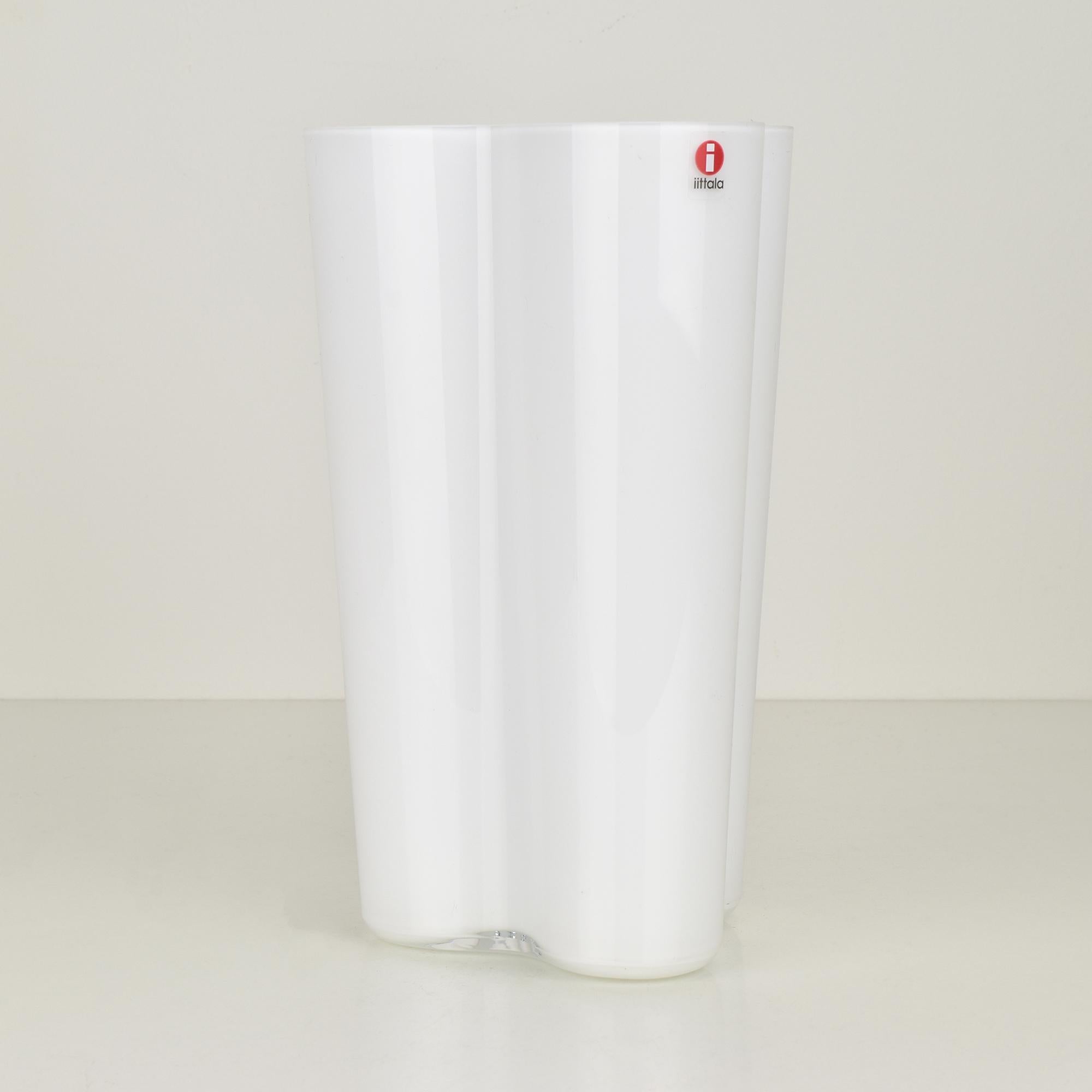 This iconic white Savoy vase, designed by Alvar Aalto for Iittala, epitomizes timeless Finnish design. Featuring the signature organic, free-flowing shape introduced in 1936, this vase has become a symbol of modern Scandinavian aesthetics. Crafted