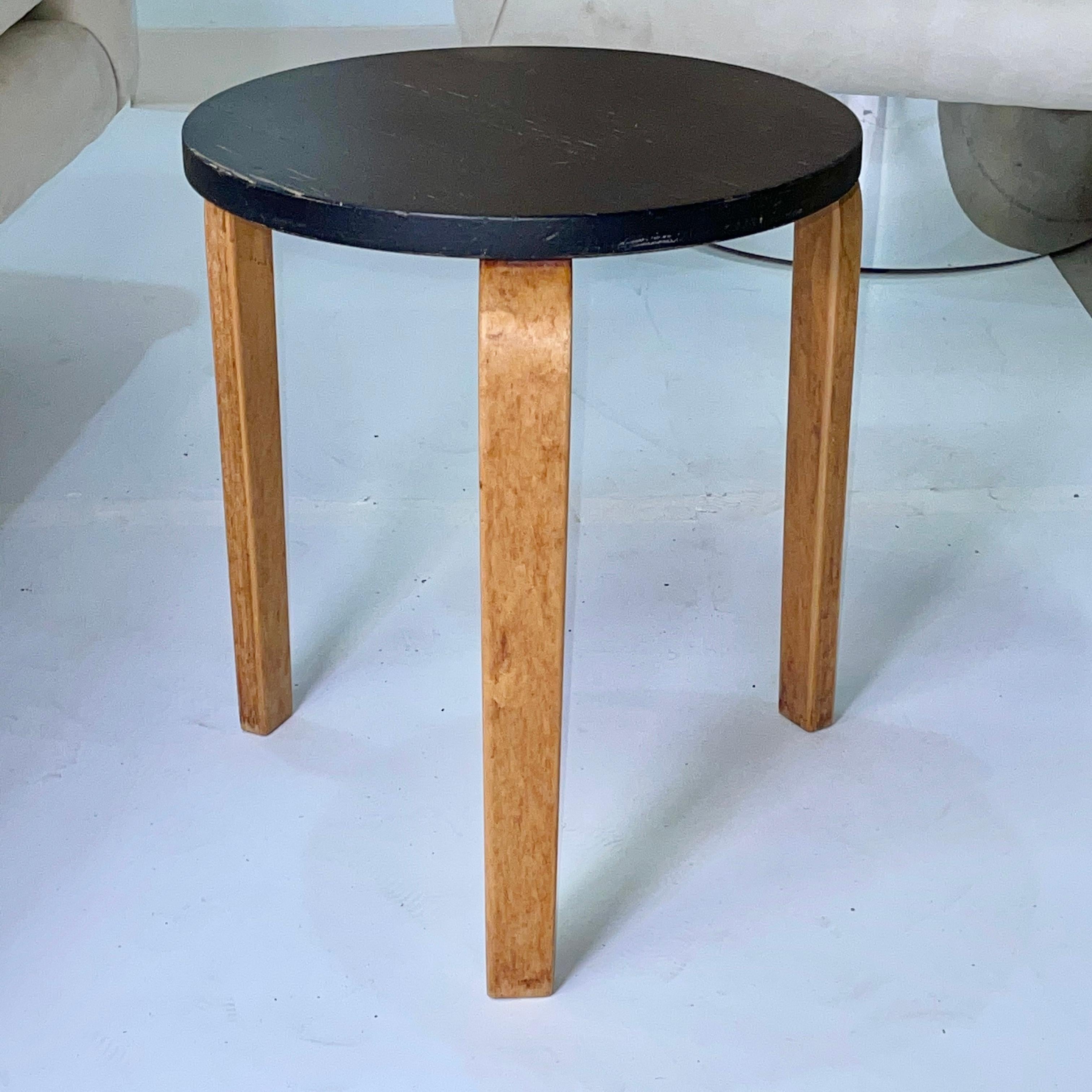 Wonderful midcentury example of Alvar Aalto's L-leg three-legged Model 60 stool in birch laminate with black painted top, produced by Artek, Finland. Measures: 17