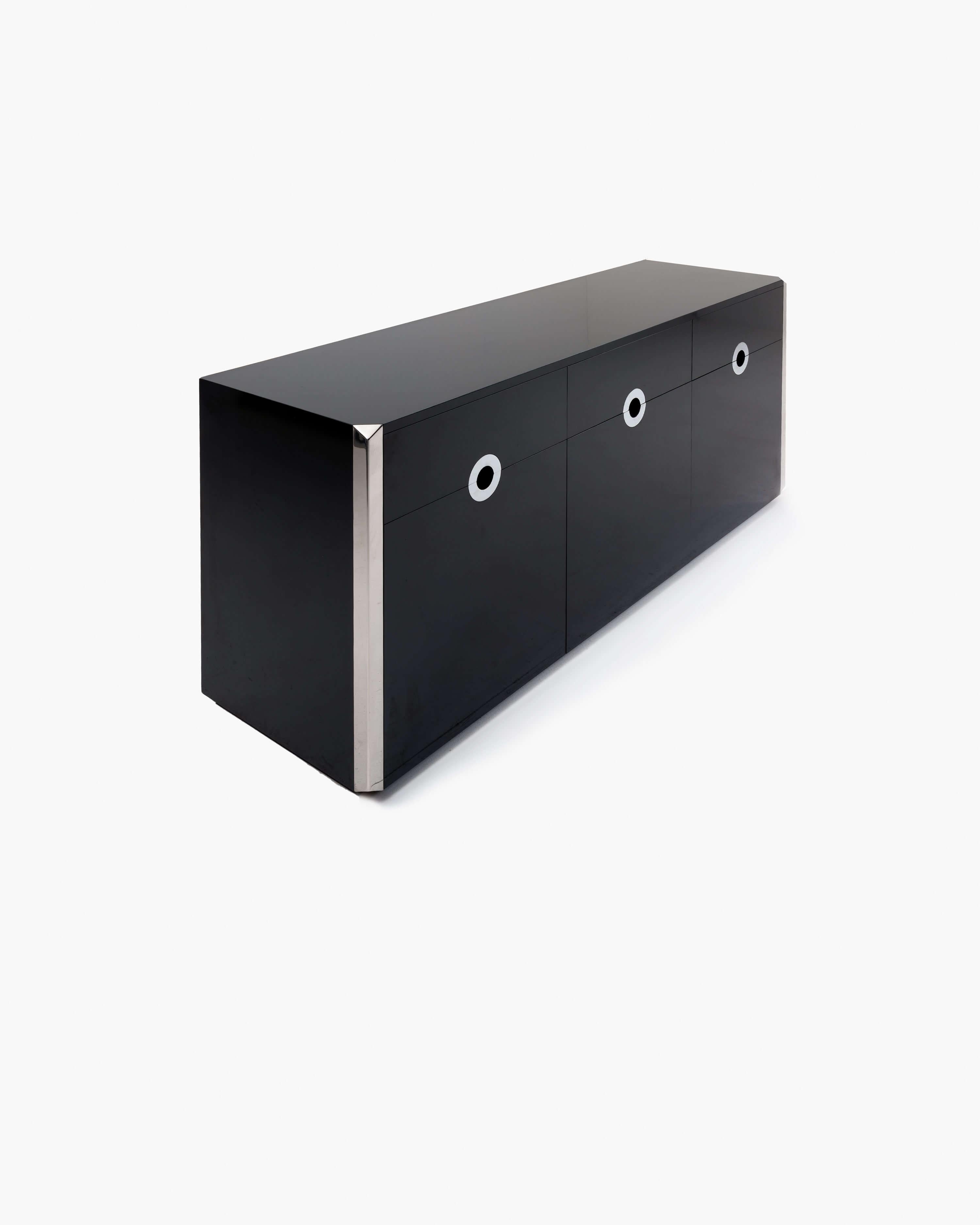 Questa sorprendente credenza di Willy Rizzo è stata progettata nel 1970 come parte della serie Alveo. Le ante a sinistra e a destra della credenza sono affiancate da un'anta centrale a ribalta, ciascuna rifinita con una maniglia a occhiello
