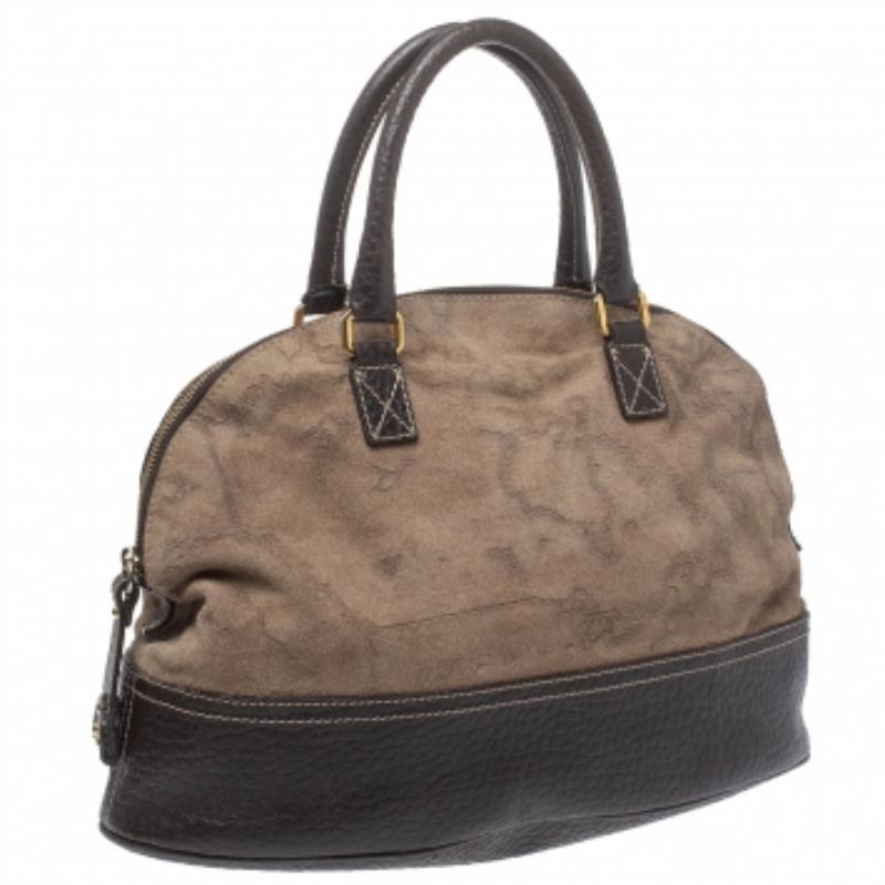 This stylish bag by Alviero Martini 1A Classe has been crafted to assist you with ease and style on all days. It is crafted from brown fabric and finished with leather trims and gold-tone hardware. The satchel features two handles, and a spacious