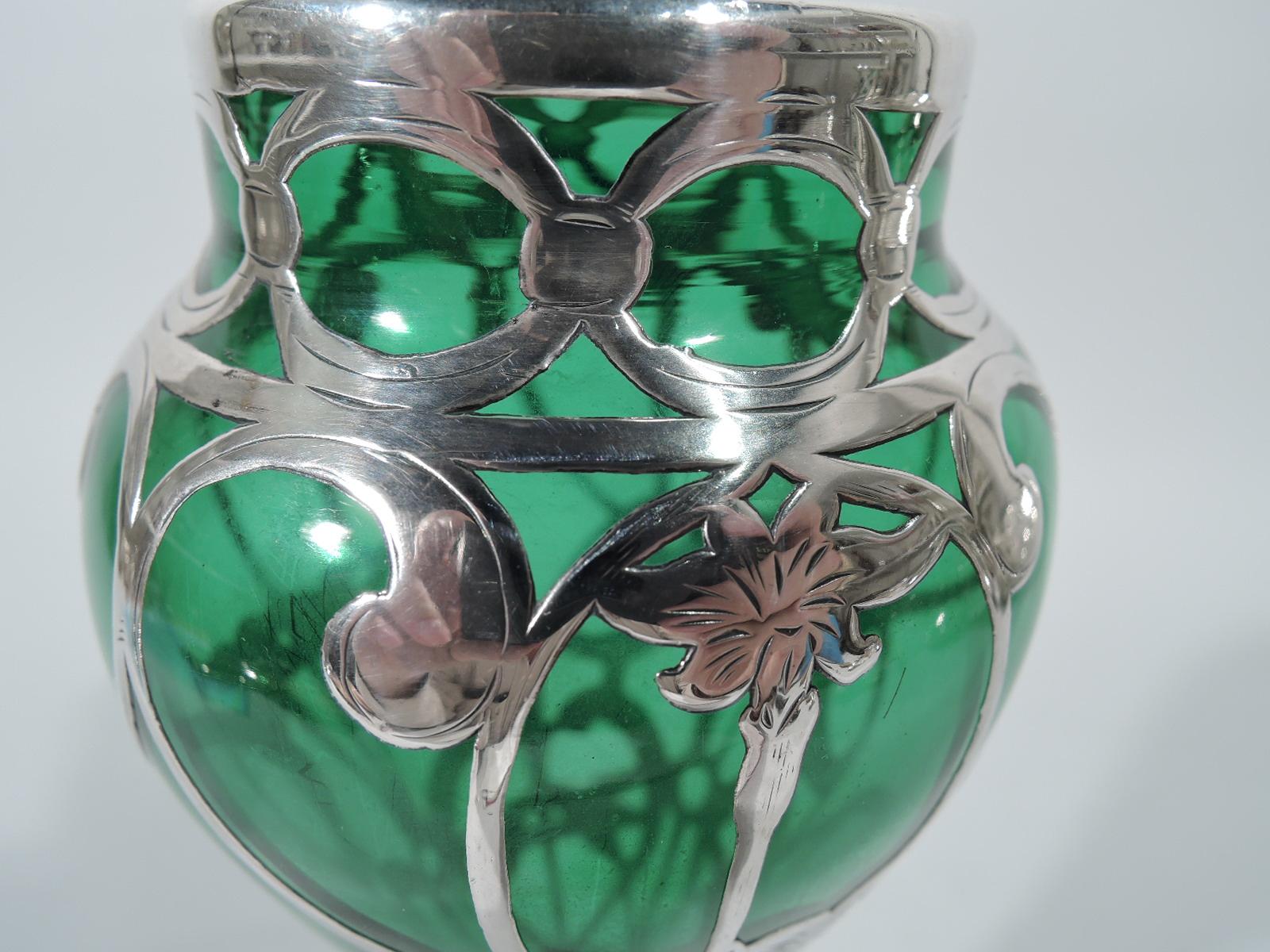 Art Nouveau emerald glass vase with silver overlay. Made by Alvin in Providence. Baluster with short straight neck and round base. Engraved overlay in form of vertical repeating pattern with curvilinear and interlaced stems and flowers. Faint mark.