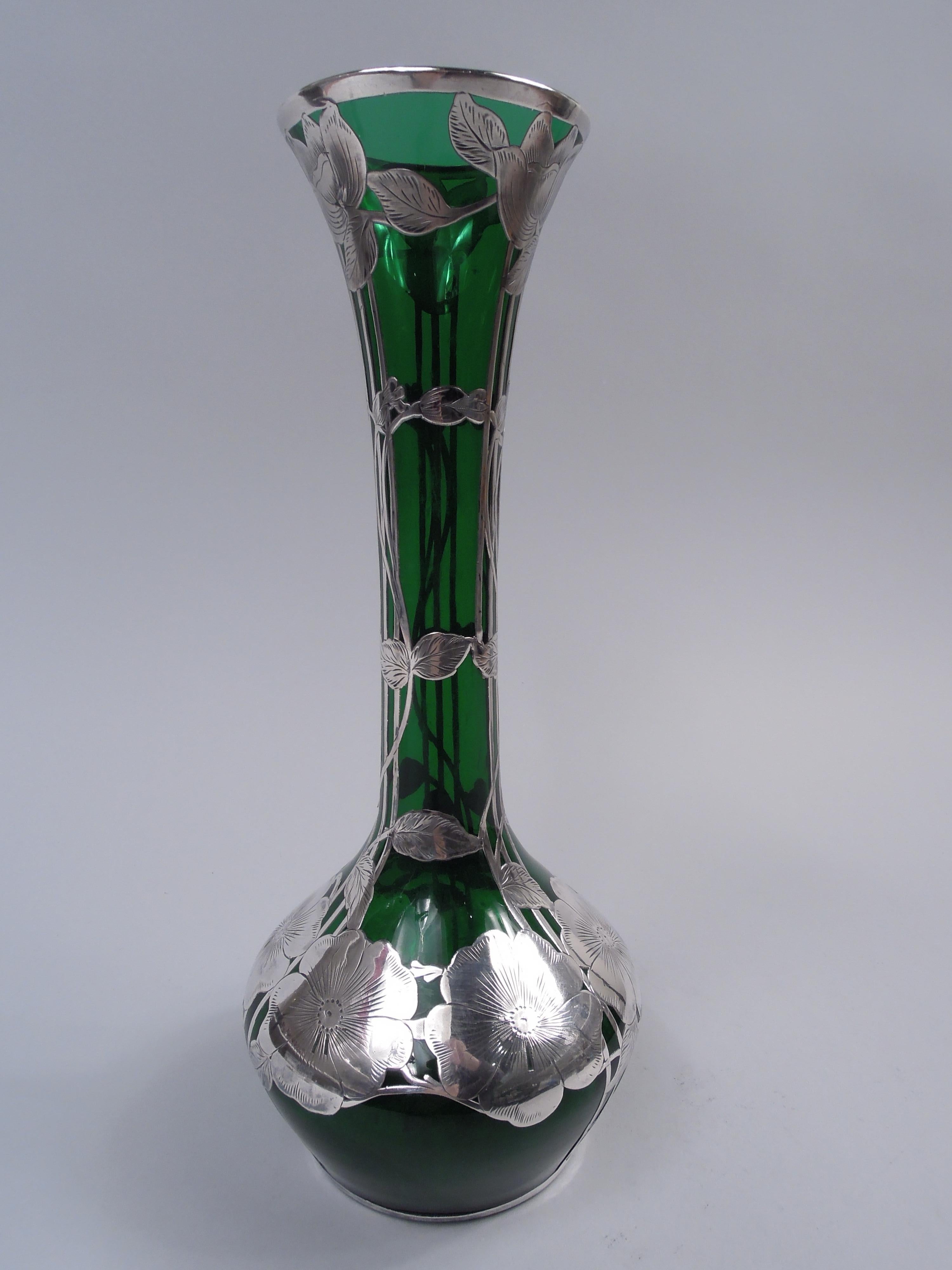 Art Nouveau glass vase with engraved silver overlay, ca 1900. Wide tapering bowl and tall cylindrical neck with flared mouth. Overlay in form of vertical trellis entwined with stem flowers on neck and on bowl shoulder a ring of big flowerheads; oval