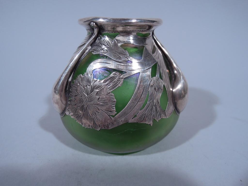 Art Nouveau iridescent green glass bud vase with silver overlay. Made by Alvin in Providence, circa 1900. Ovoid with engraved silver overlay in repeating floral pattern, and 3 thick teardrop drips, an exciting foray into abstraction. The glass is