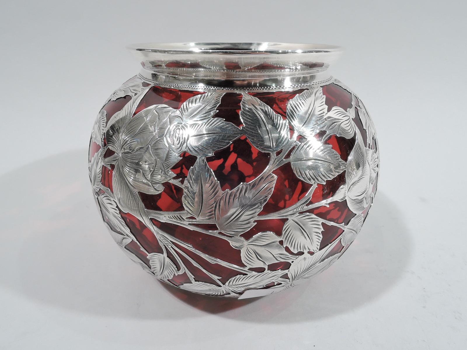 Turn-of-the-century Art Nouveau glass bowl with engraved silver overlay. Made by Alvin in Providence. Globular with flared rim in silver collar. Overlay in form of flowering rose branches. Round shaped and scrolled cartouche (vacant). Glass is red.