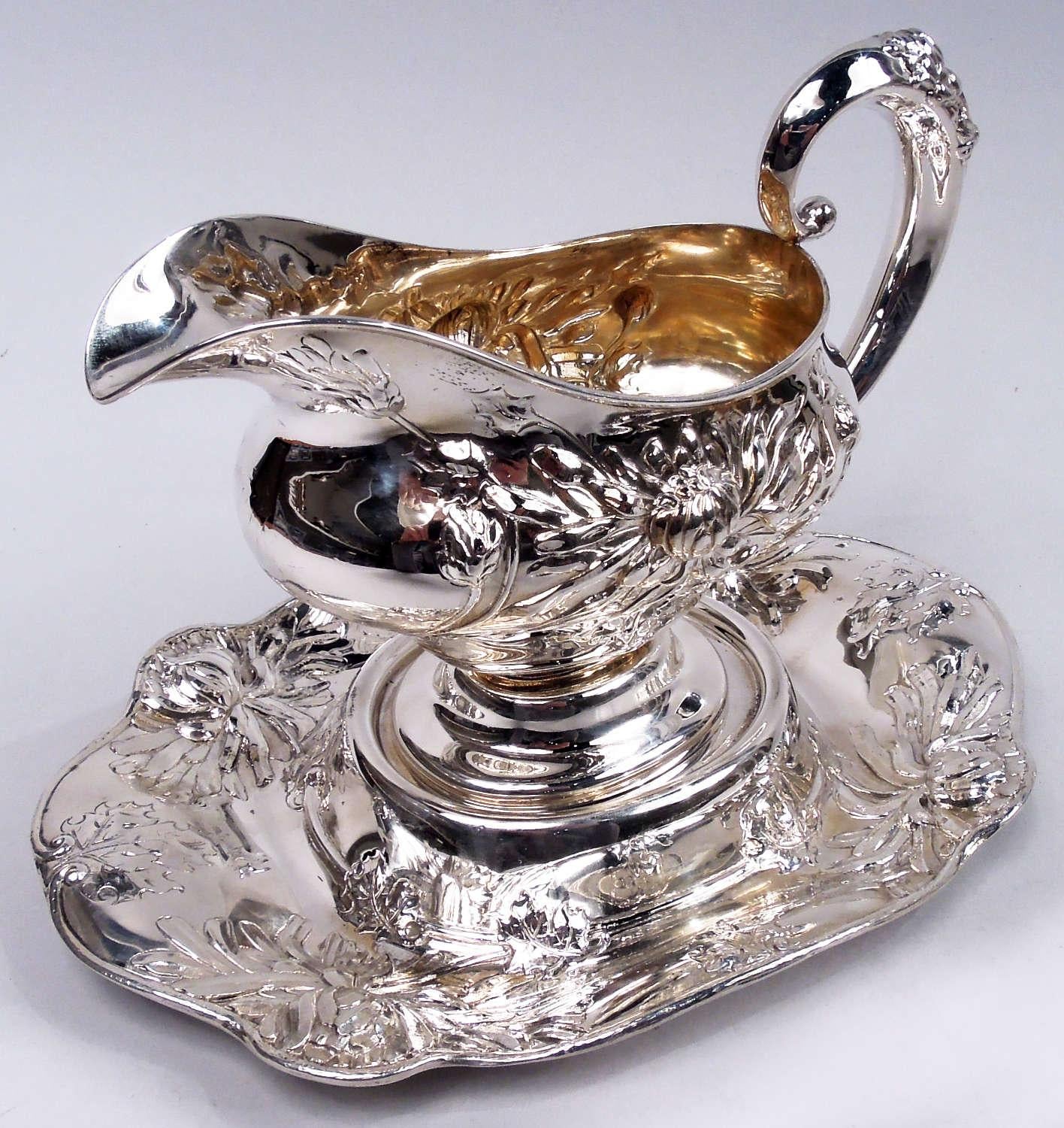 Salsera japonesa de plata de ley sobre soporte. Fabricado por Alvin Corp. en Provenza, hacia 1890. Barco: Cuenco panzudo con boca de casco, asa alta y pie abovedado; interior dorado. Pie: Laterales curvados y cóncavos y borde con volutas; centro