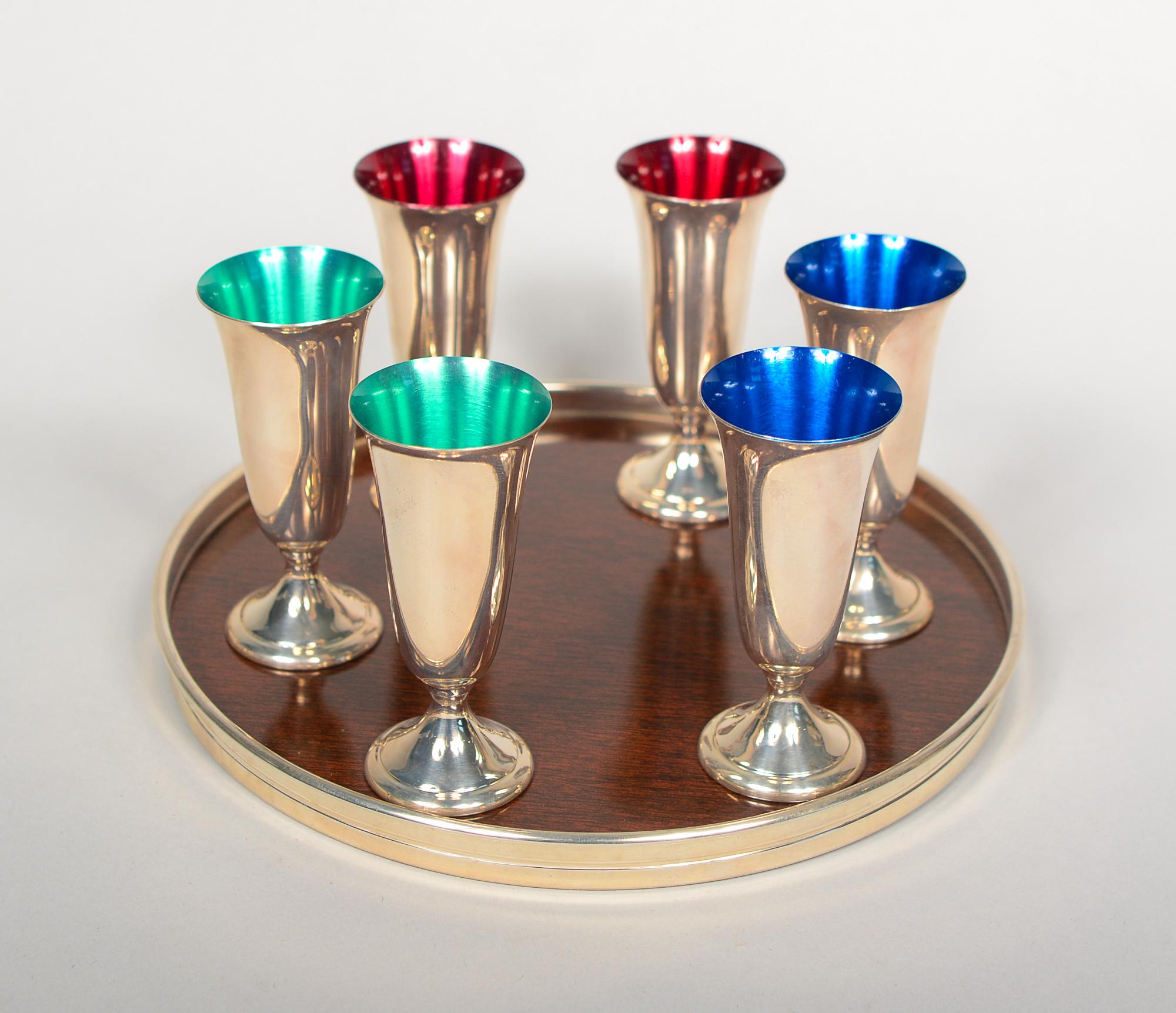 Set of six sterling silver cordials with a serving tray by Alvin Silver Co. The interior of the cordials are enameled red, green or blue. The tray has a sterling rim. The center of the tray is plastic with a faux wood grain. The cordials are 2 7/8