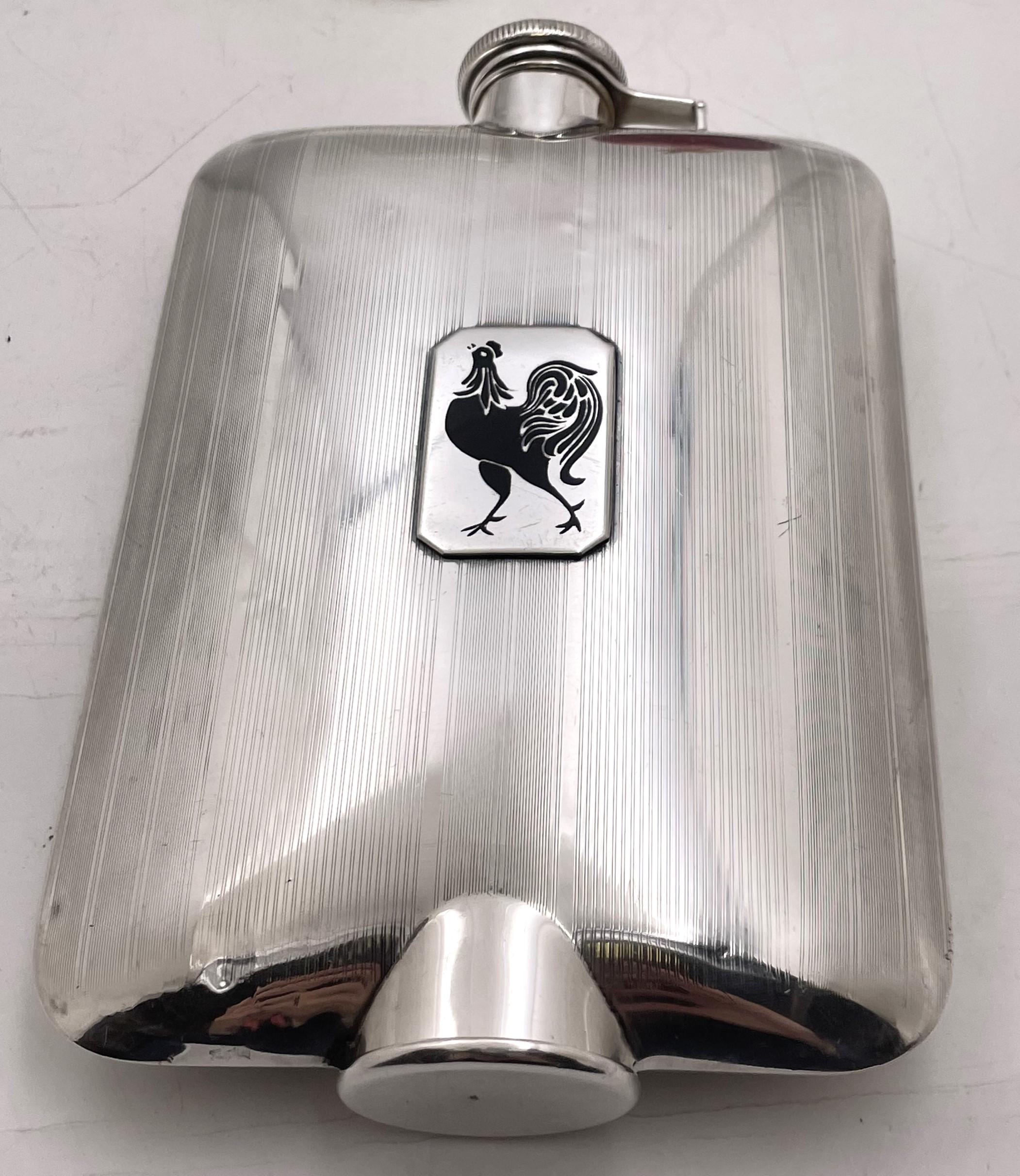 Fiaschetta in argento sterling di Eleg in stile Art Déco con un elegante design geometrico, risalente agli inizi del XX secolo. Con una placca applicata raffigurante un gallo in smalto nero e un bicchierino integrato, anch'esso dorato all'interno,