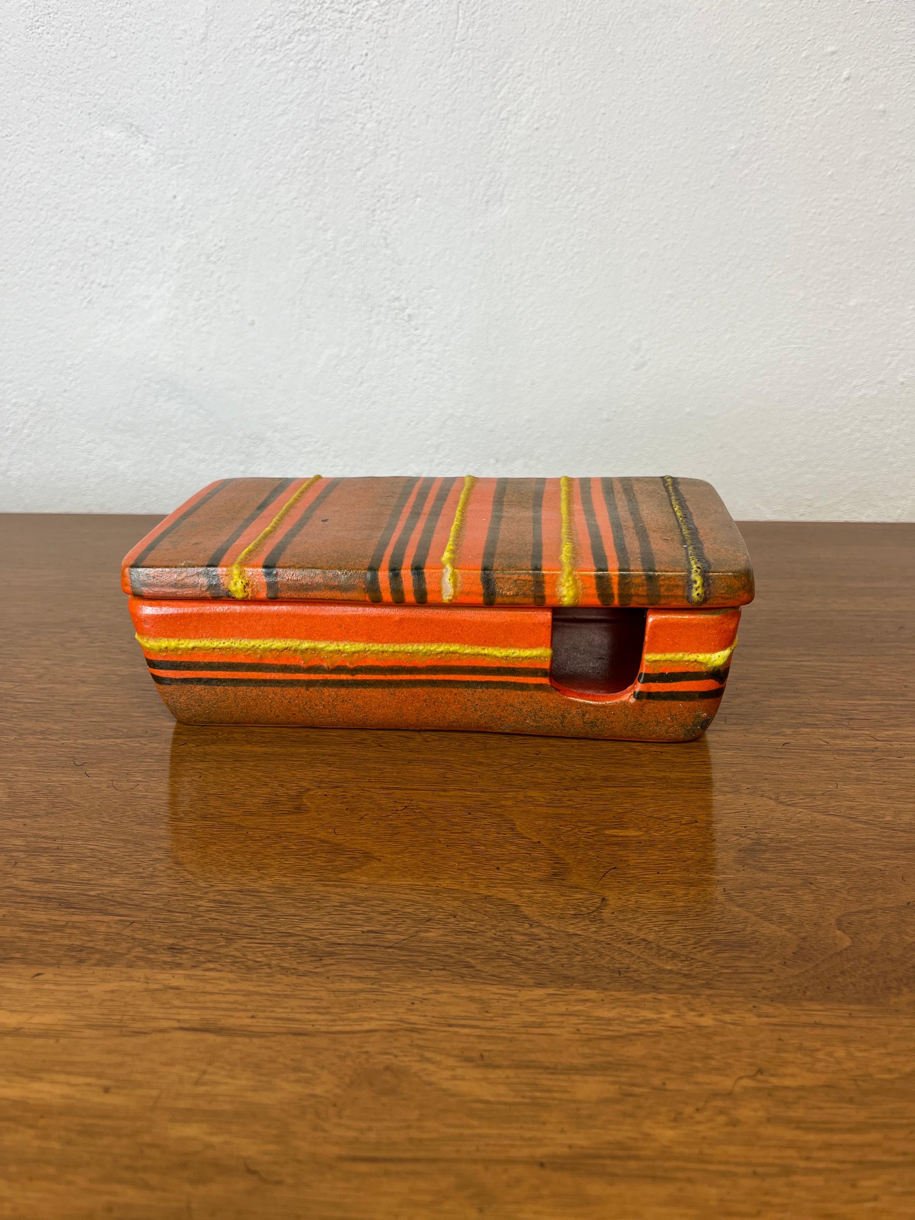Beautiful example of mid century Italian pottery. Alvino Bagli for Raymor lidded box in a great period orange with yellow, brown and black accent. 
 It is a beautiful box and hard to find. Originally designed to hold small ashtrays and smokes. 