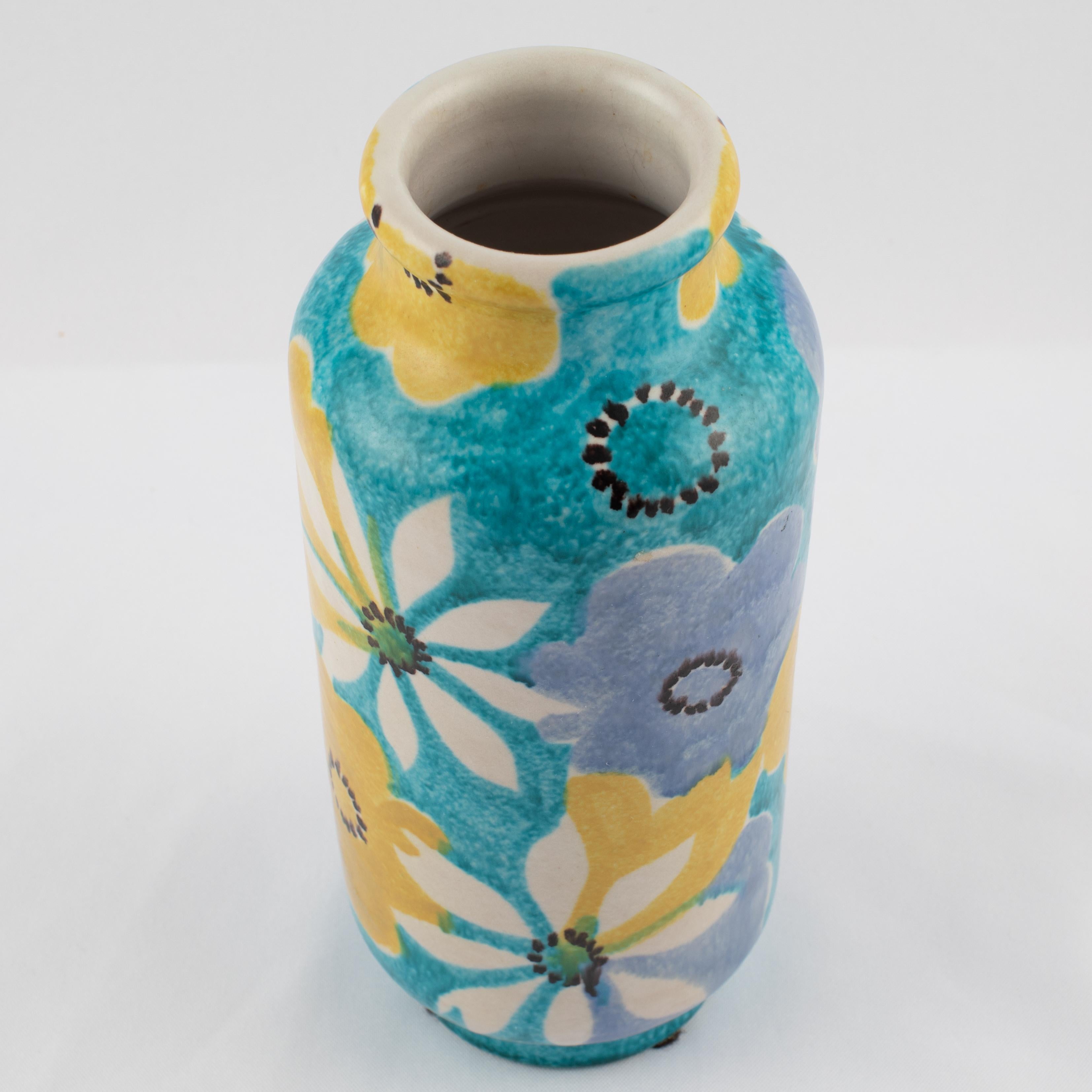 Lovely cylindrical vase glazed with hand painted blue, white and yellow flowers on an aqua background, by Italian ceramicist Alvino Bagni for American importer Raymor. Signed 