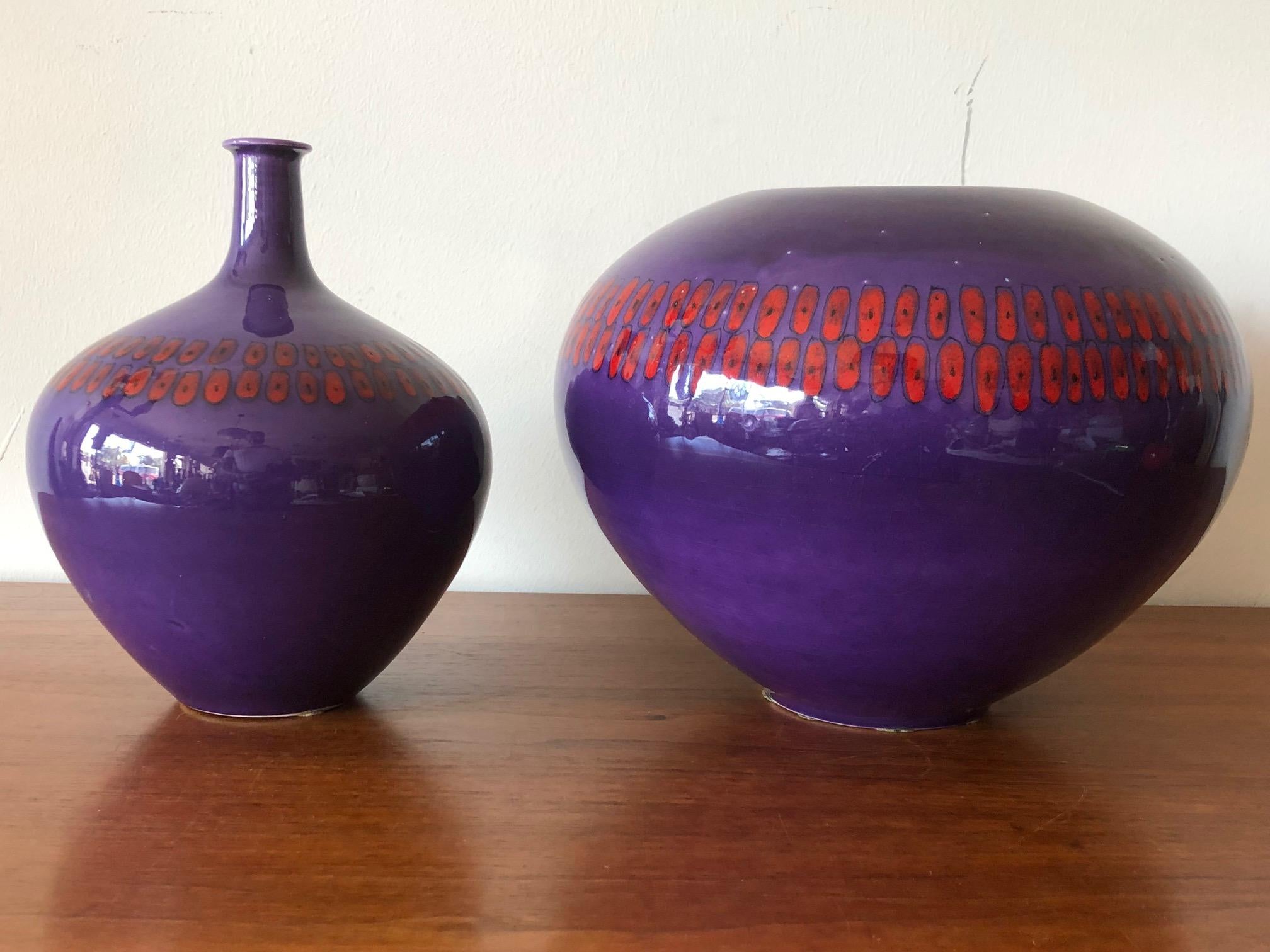 Two stylish vases by Alvino Bagni for Raymor, circa 1960s. Shiny purple glaze with red decorative detail. Both signed on the bottom, one measures 10
