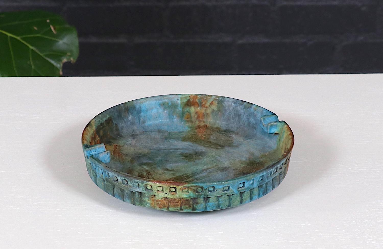 This exquisite Mid-Century Modern ceramic bowl by Alvino Bagni for Raymor is a stunning example of Italian craftsmanship. The hand-glazed surface features a mesmerizing blend of blue, green, and earthy tones, creating a dynamic patina that enhances