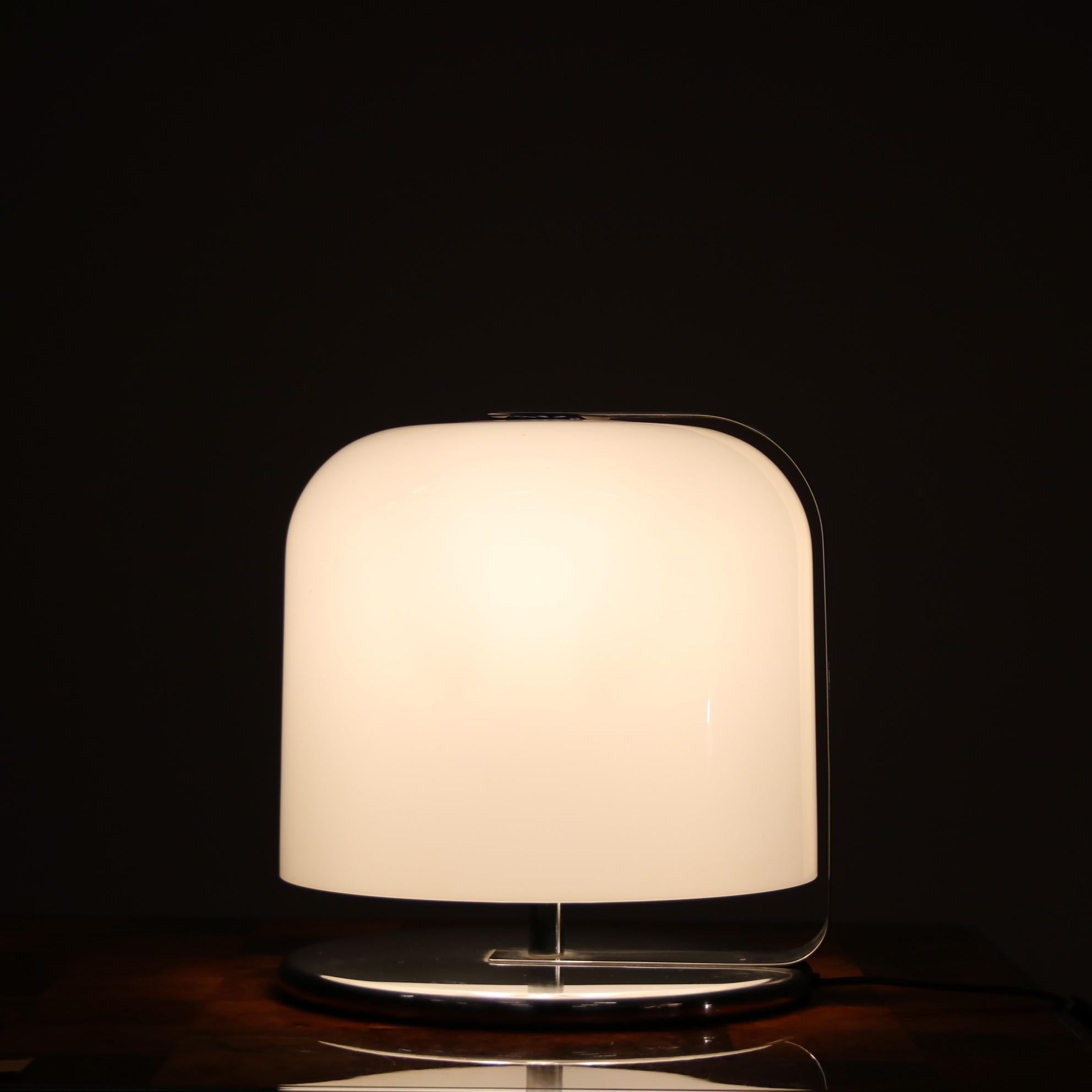 A much sought after table lamp, model “Alvise”, designed by Luigi Massoni and manufactured by Guzzini in Italy around 1960.

This stunning piece is made of high quality chrome plated metal, with a round foot and flat bent arm holding the large and