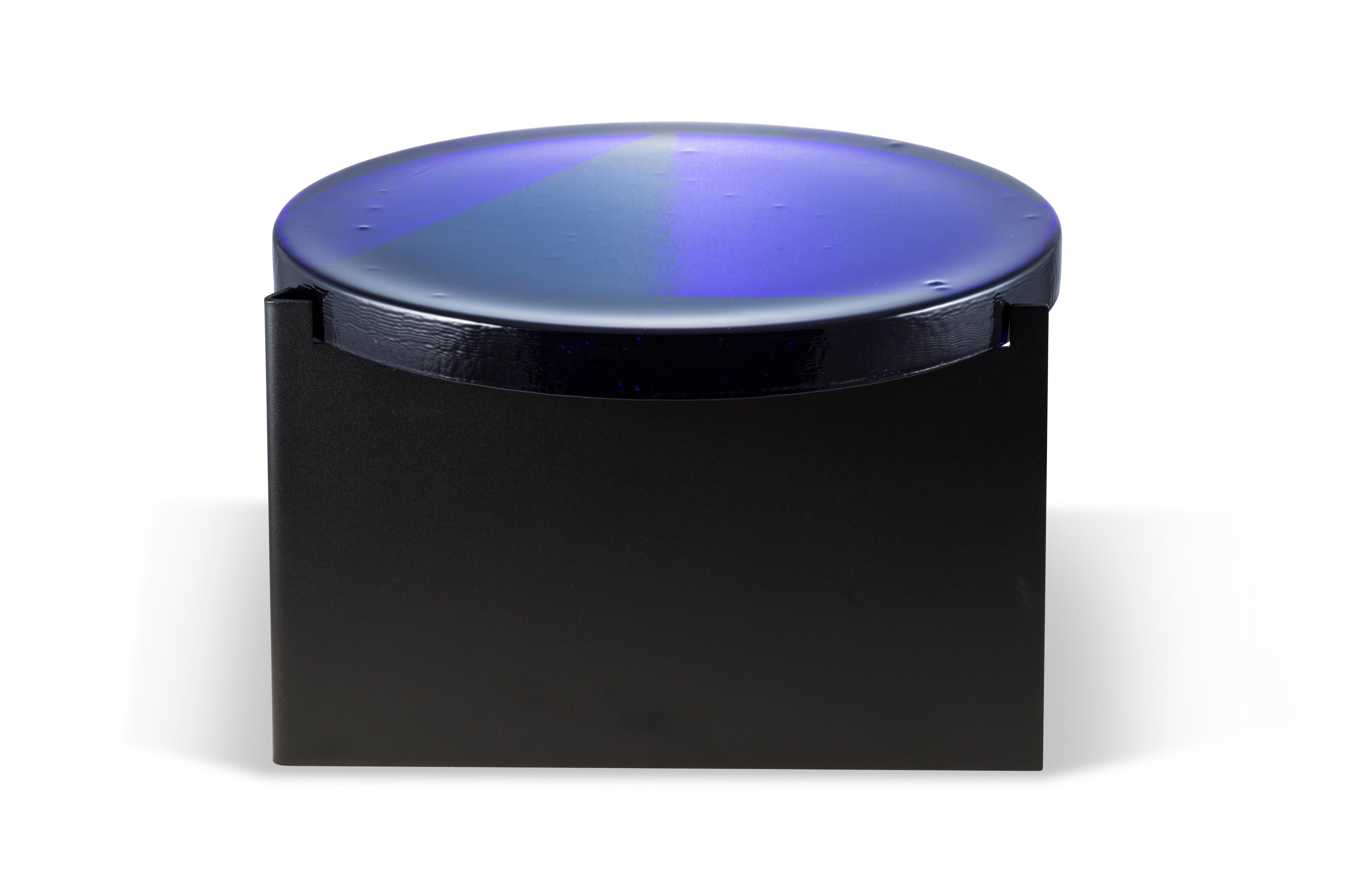 Alwa one big blue black coffee table by Pulpo.
Dimensions: D56 x H35 cm.
Materials: casted glass; powder coated steel.

Also available in different finishes. 

Normally, glass is regarded as being lightweight with sharp edges. In contrast,