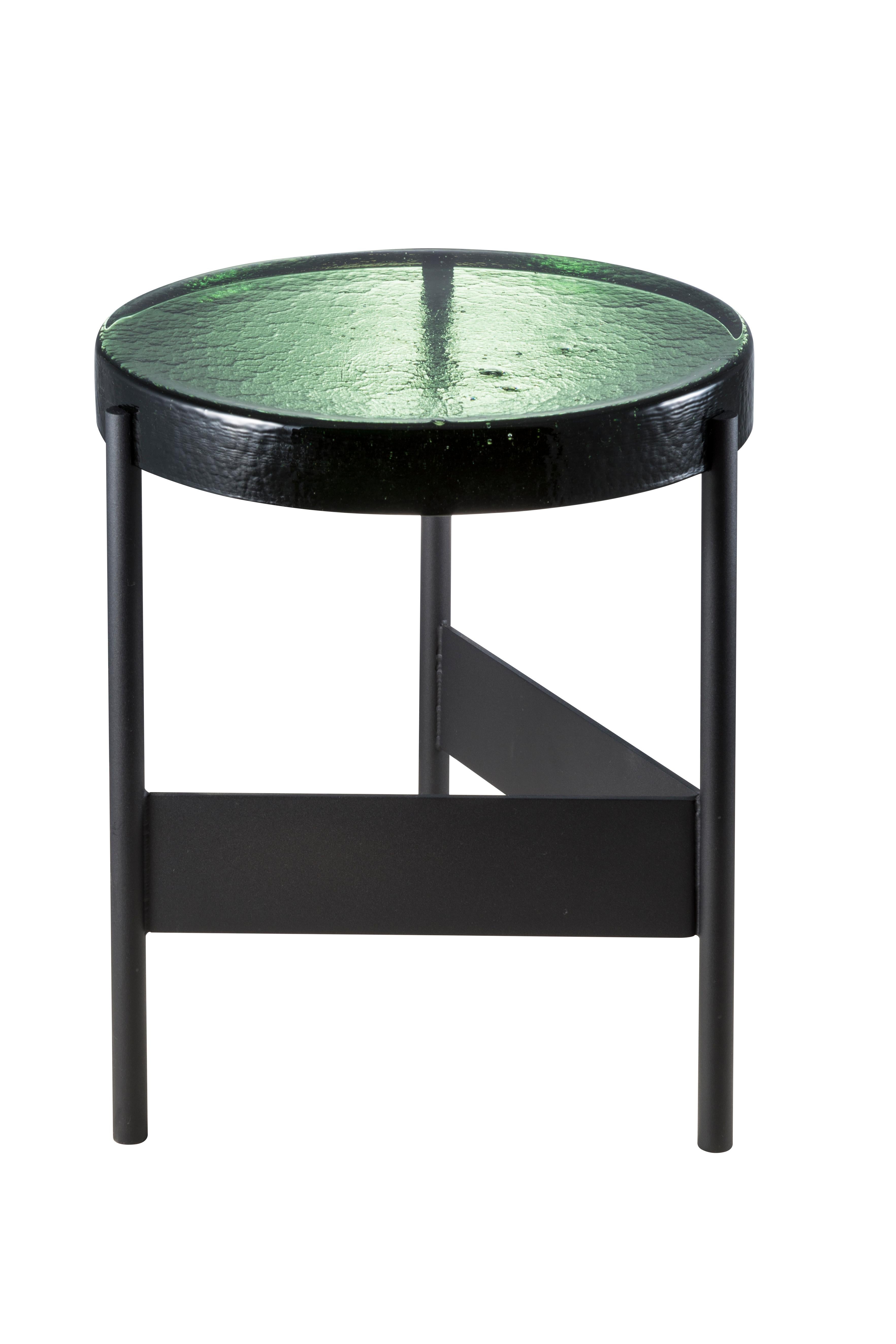 Alwa two green black side table by Pulpo.
Dimensions: D38 x H44 cm.
Materials: casted glass; powder coated steel.

Also available in different finishes. 

Normally, glass is regarded as being lightweight with sharp edges. In contrast,