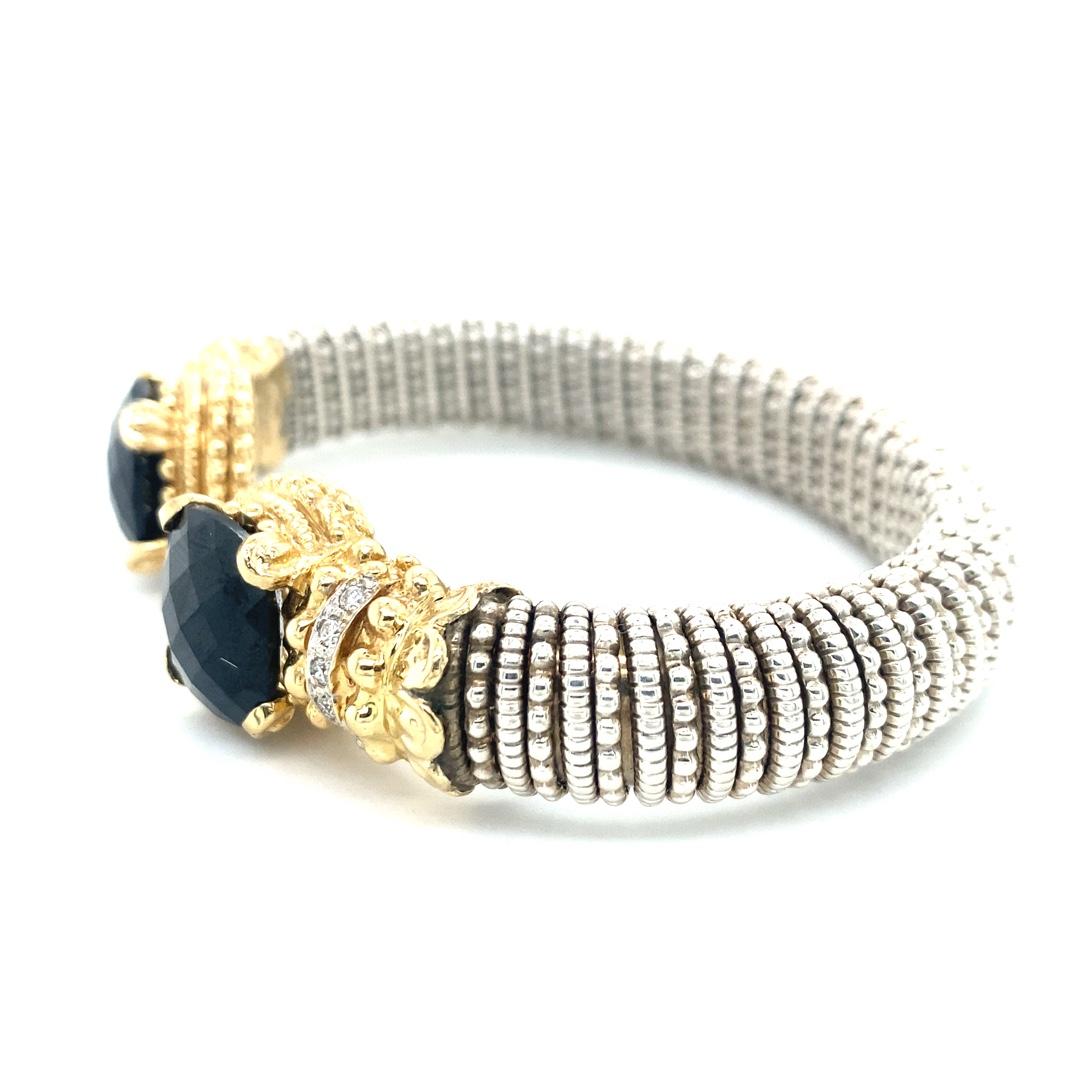 This stunning cuff is made by Alwand Vahan. The bracelet is 12mm wide and is made of sterling silver and 14k gold. There is 0.25ctw of diamonds and two cushion cut black onyx stones. Don't miss out on this beautiful piece!