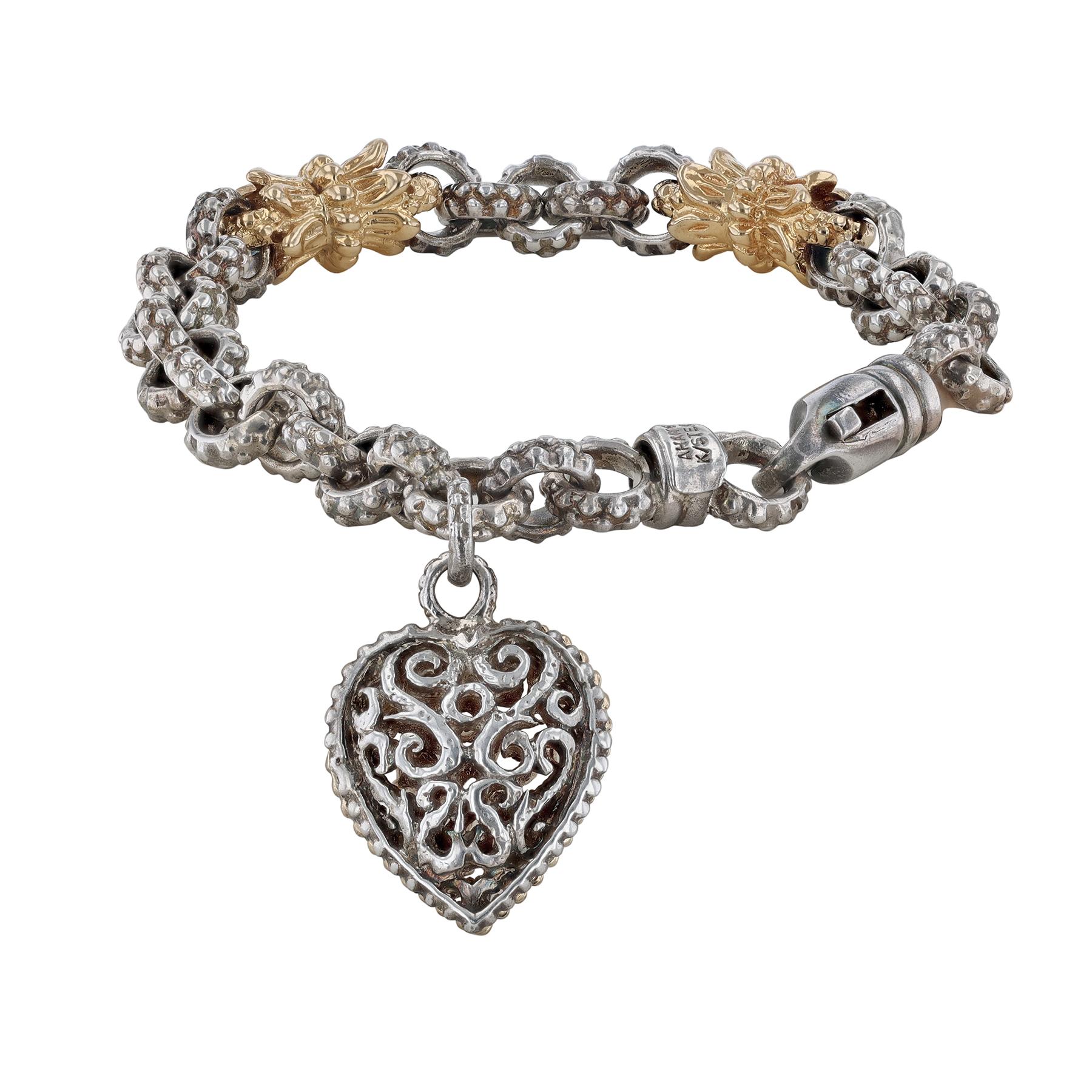 This link bracelet is made in sterling silver with a 14K gold accents heart charm. 