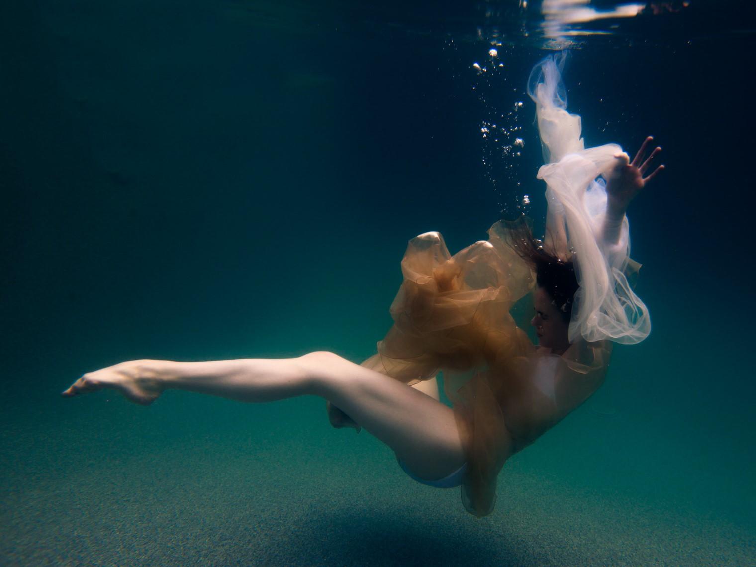 This contemporary figural limited edition photograph by Alyssa Fortin titled "Odette's Last Breath Before..." is a reinterpretation of the mythological story of Odette, the swan from Swan Lake. In this image, a female figure wearing a dress made of