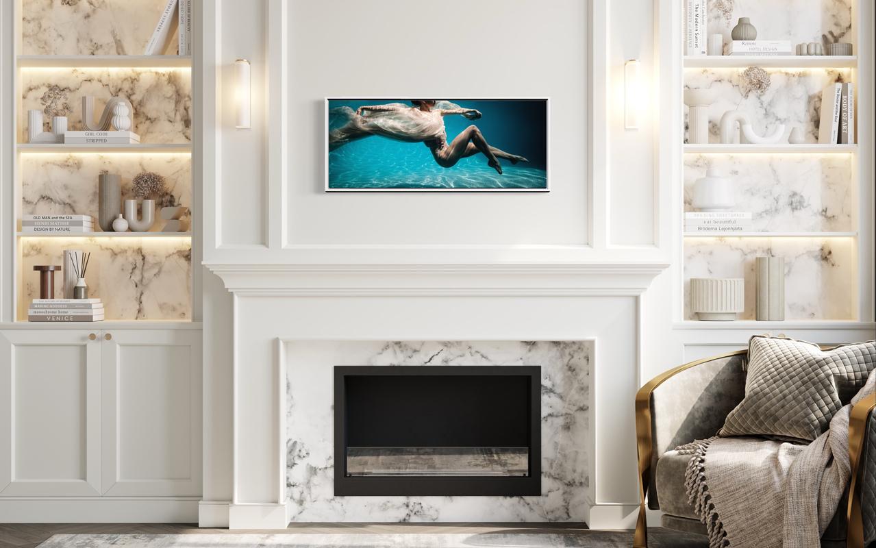 Cette photographie contemporaine en édition limitée d'Alyssa Fortin représente une silhouette féminine, enveloppée d'un tissu léger et doux, flottant sous la surface d'une eau bleue dans une pose de danseuse. 