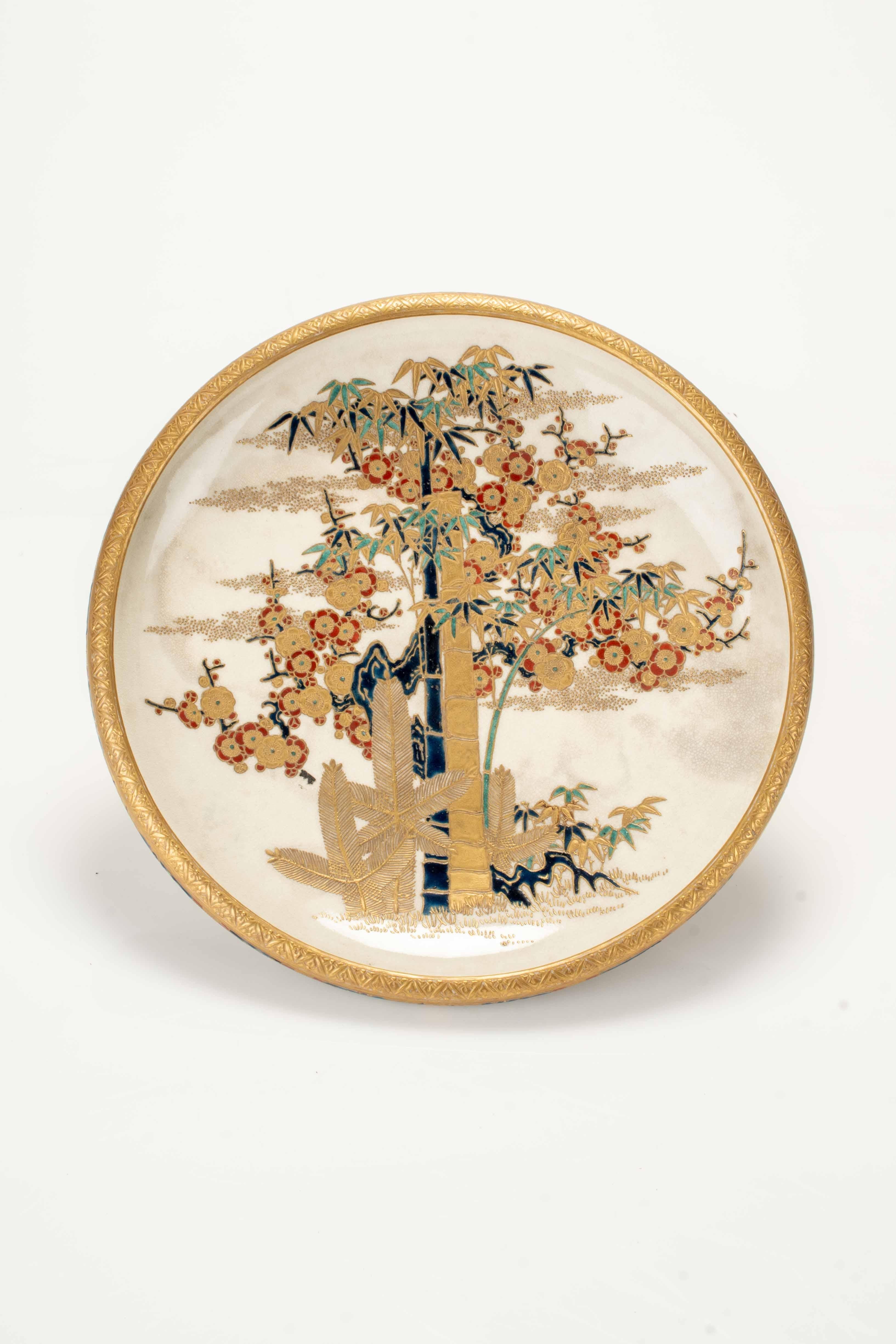 Alzata in ceramica Satsuma a tre piedini, decorata con il motivo tradizionale shochikubai, che unisce i tre simboli botanici della cultura giapponese: il pino (matsu), il bambù (take) e il pruno fiorito (ume), eseguiti in oro e smalti policromi nei
