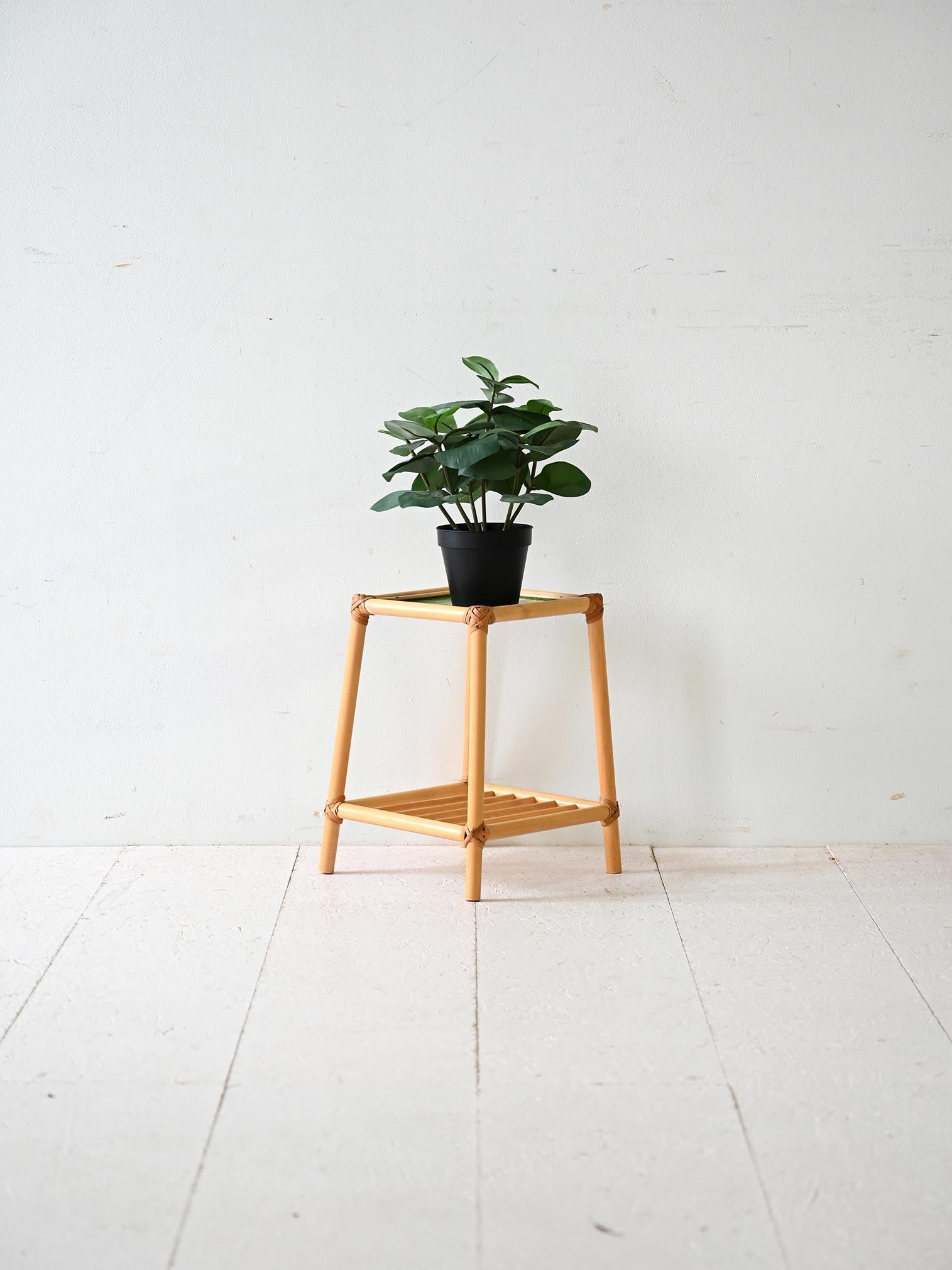 Plaque d'appui en bambou vintage raffiné avec dessus en verre vert, parfait pour les plantes ou les petits objets décoratifs.

Ce porte-vase en bambou au design léger et essentiel est un meuble polyvalent et discret. Le plateau en verre vert apporte