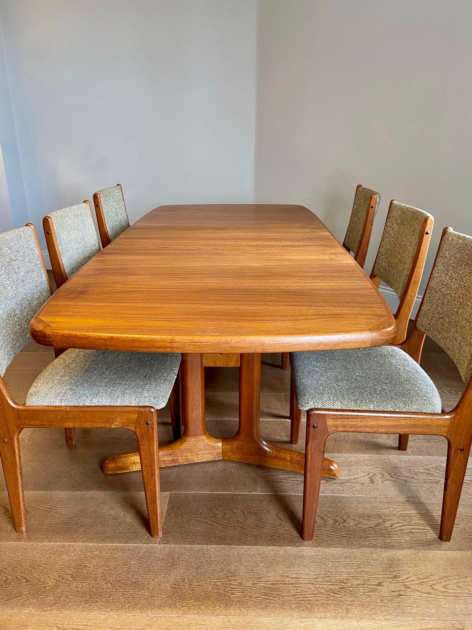 Wonderful teak dining table with six matching chairs from AM Møbler, Denmark. 
Crafted in solid teak wood with a fabulous contrast in color to its corners. Stamped 'AM Denmark' on the underside part of the table. The chairs are made with the same