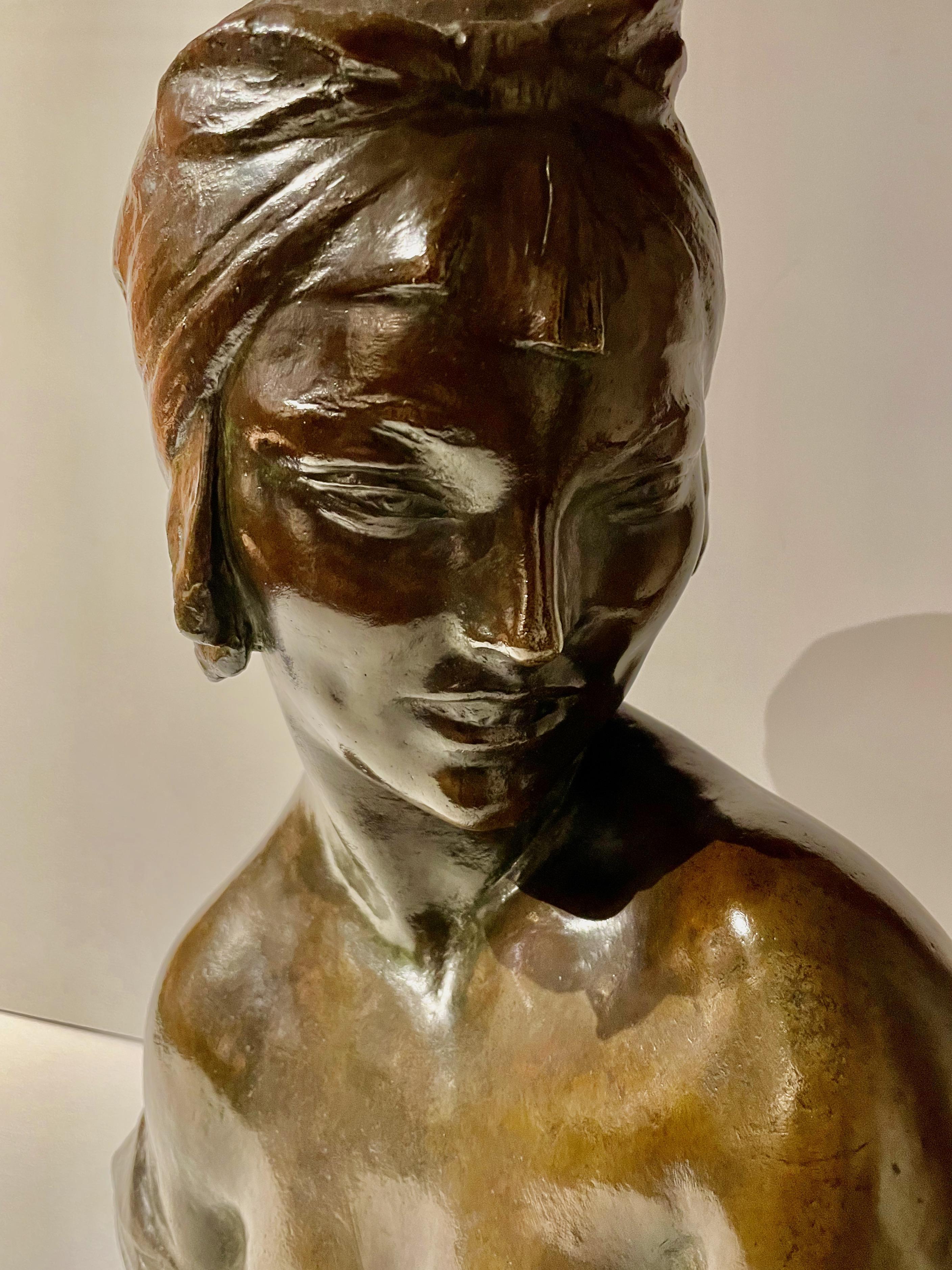 An original patinated bronze bust by Amedeo Gennarelli circa 1925. This slightly nude model is depicted from her shoulder, looking forward with a stylized turban on her head. A stunning deep bronze patina was signed in the cast 'A.Genneralli.' The
