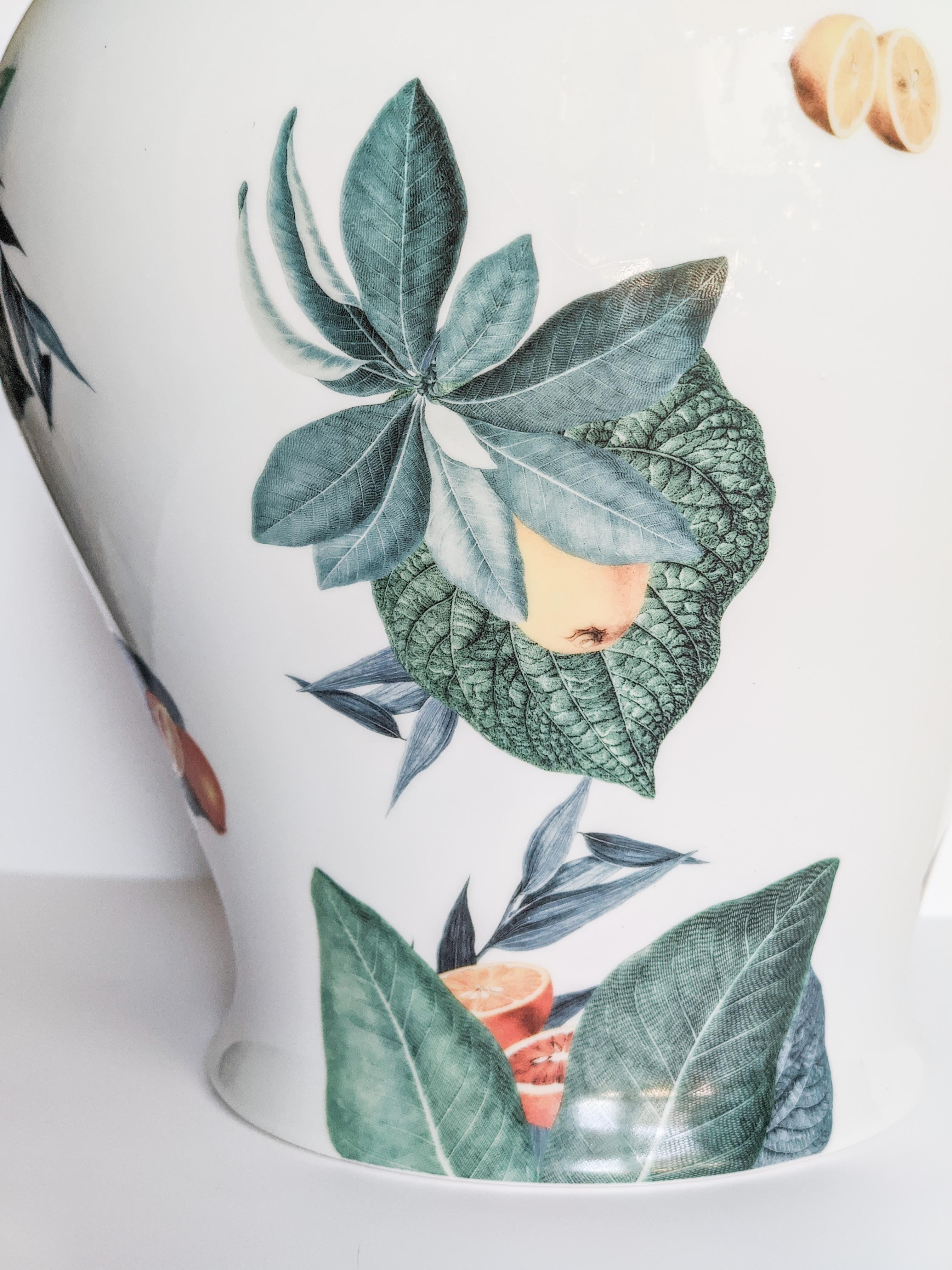 Le design classique de ce vase en porcelaine revient à la vie avec des décorations rétro à saveur contemporaine. La côte italienne d'Amalfi inspire ce motif où les feuilles et les agrumes s'assemblent et volent sur toute la surface.