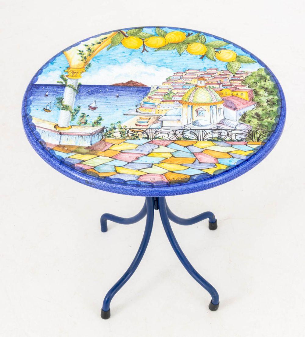 Mesa auxiliar con tablero de piedra de lava y paisaje de la costa de Amalfi, tablero circular policromado pintado a mano sobre una base de metal pintado de azul, tablero firmado. 19,5