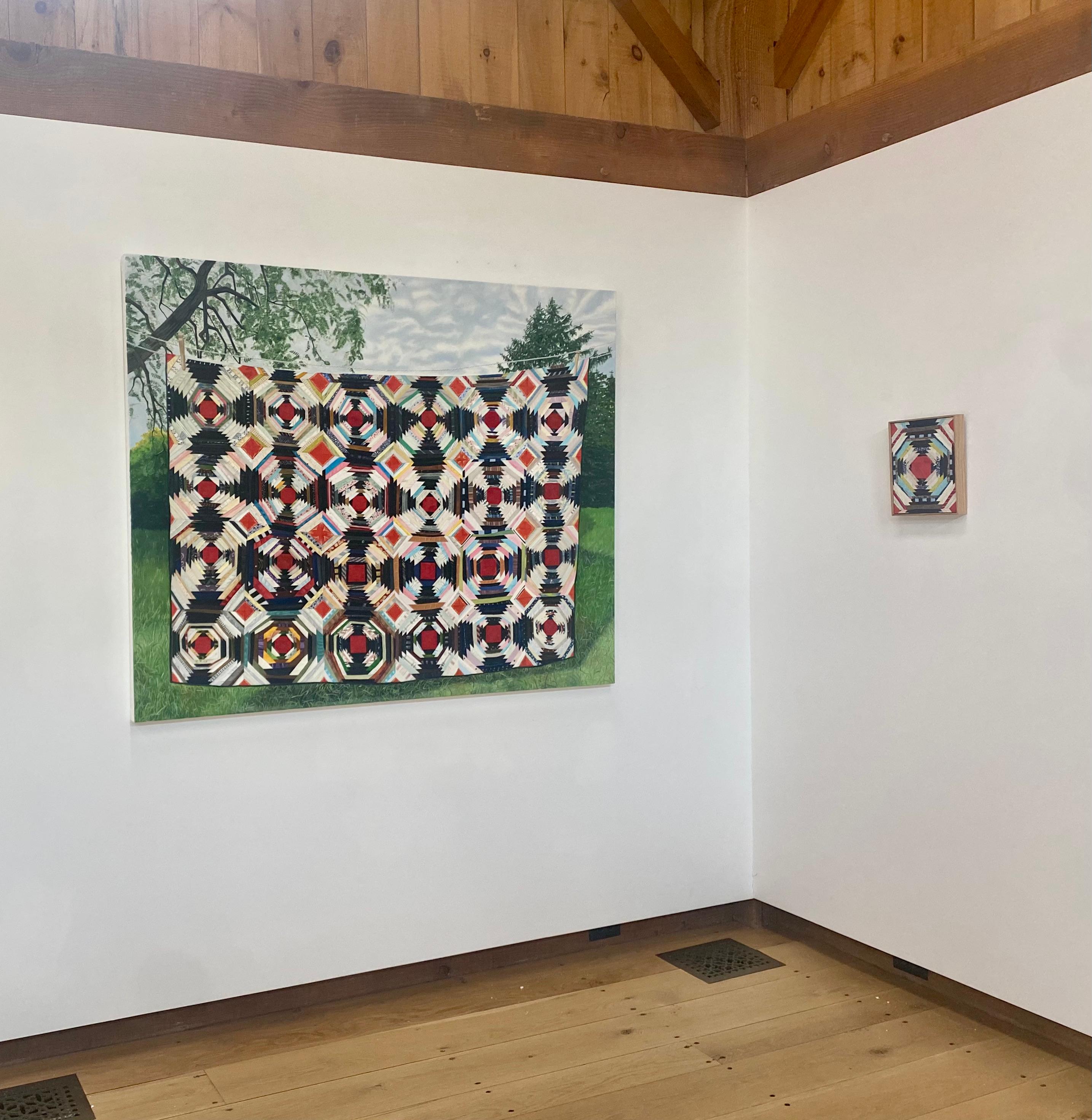 Dans cette peinture à l'huile contemporaine sur panneau représentant un paysage de jardin luxuriant, un grand édredon à motifs colorés (rouge, noir, rose, blanc, bleu et jaune) est suspendu à une corde à linge devant des arbres et un ciel bleu