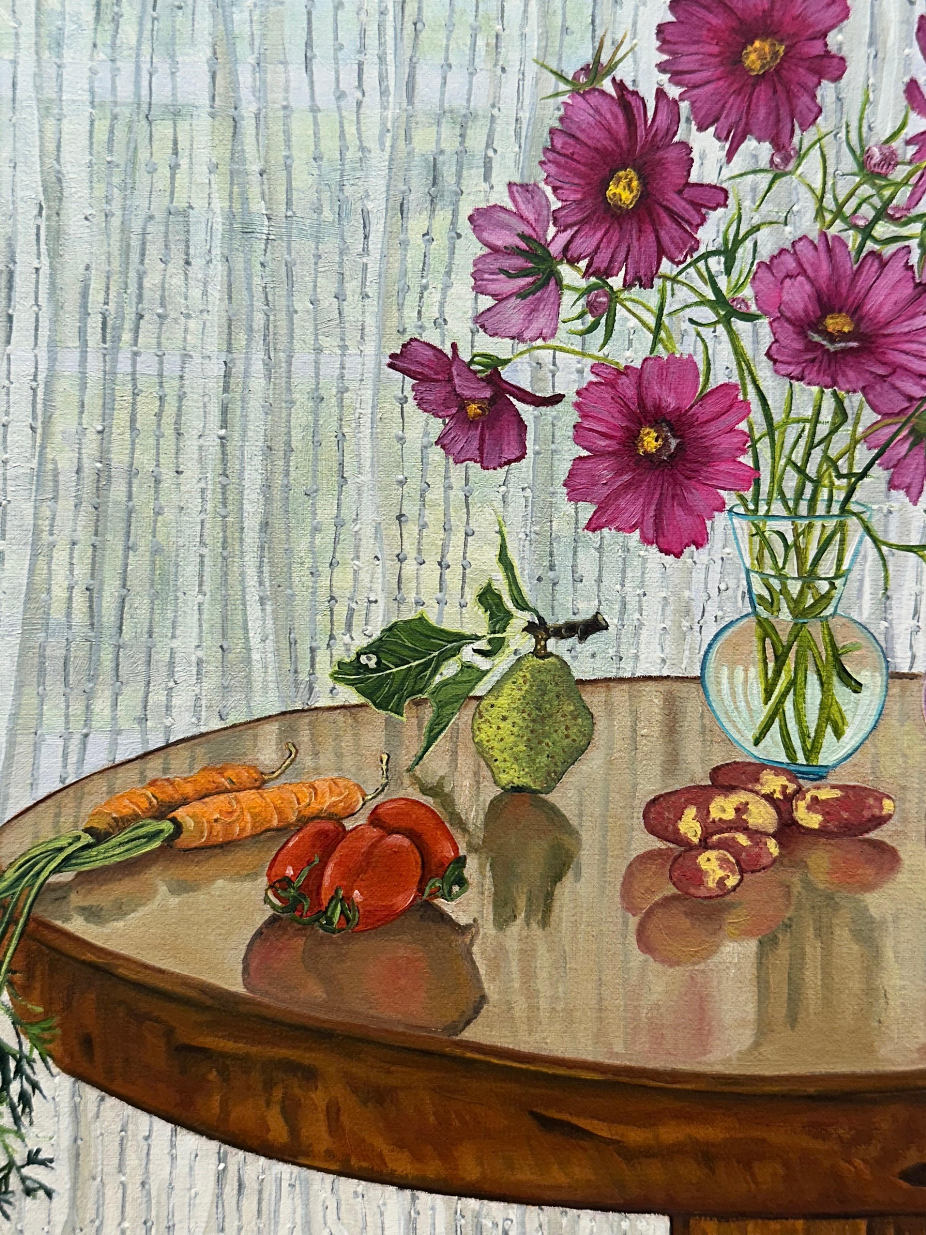 En este bodegón contemporáneo pintado al óleo sobre tabla, unas flores moradas en un jarrón de cristal se posan sobre una mesa de madera con el botín de una cosecha otoñal esparcido por la mesa: lechuga de hoja verde, tomates rojos, zanahorias