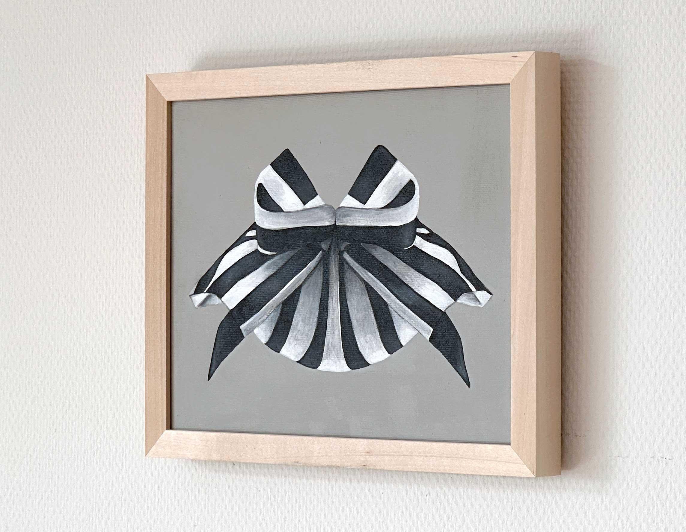 A small abstract painting made in 2023 by Amanda Andersen.
An elegant, intimate piece of art, depicting a delicate ribbon that is tied firmly in a structured, sharp, bow on a solid grey background. The contrasting black and white stripes are festive