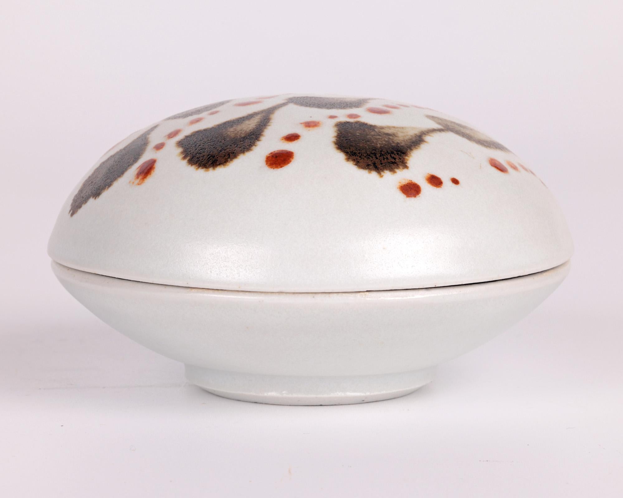 A fine and well crafted Leach Pottery studio pottery porcelain lidded pot decorated with stylized leaf and berry patterning by accomplished potter Amanda Brier and dating from the early 21st century. 

Amanda studied Studio Ceramics at Falmouth