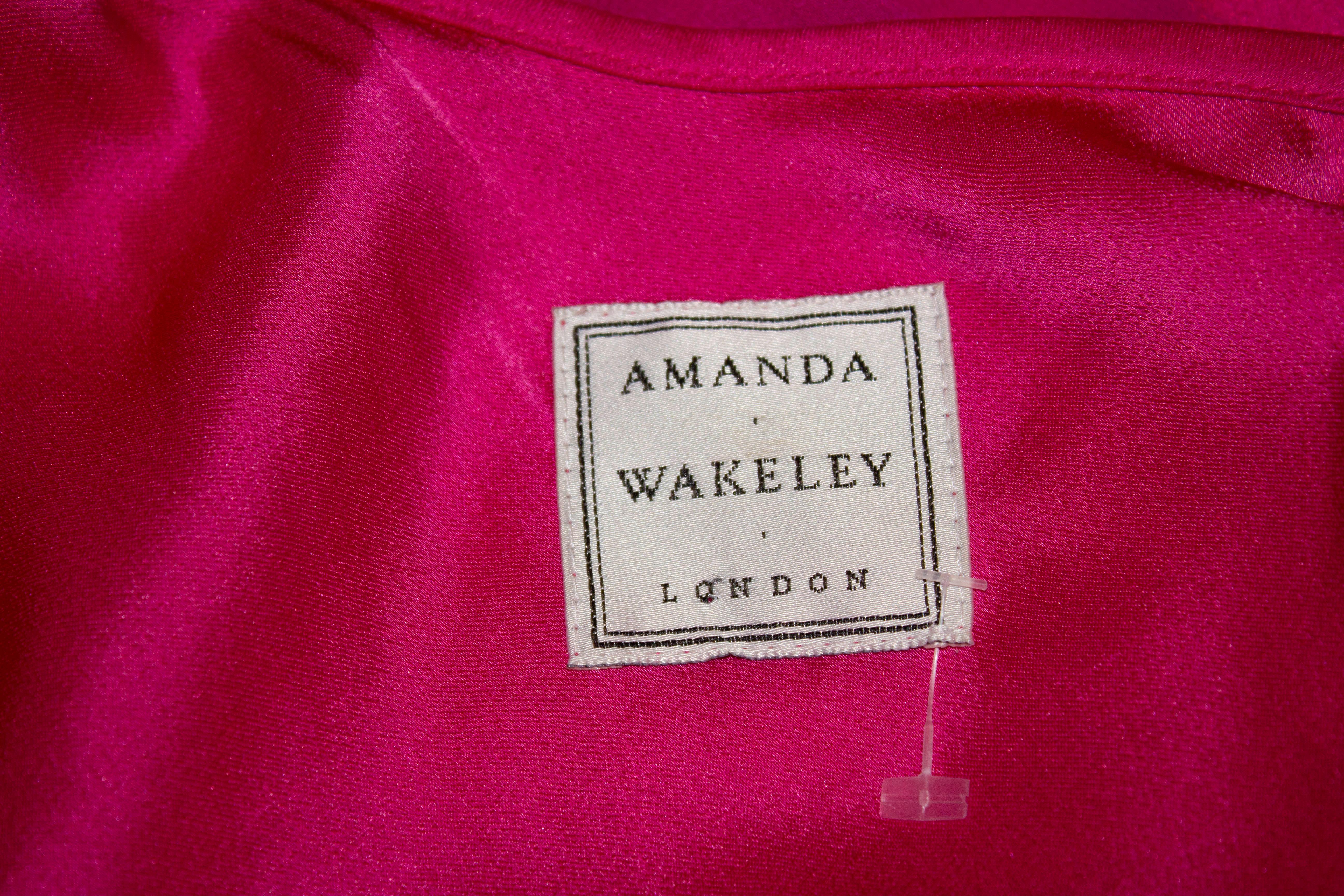A head turning evening gown by Amanda Wakeley . In a pink silk with embellishment the gown has a cowl neckline, deep back , spaggeti straps and embroidery detail.
Measurements: Bust 36'', length 59''