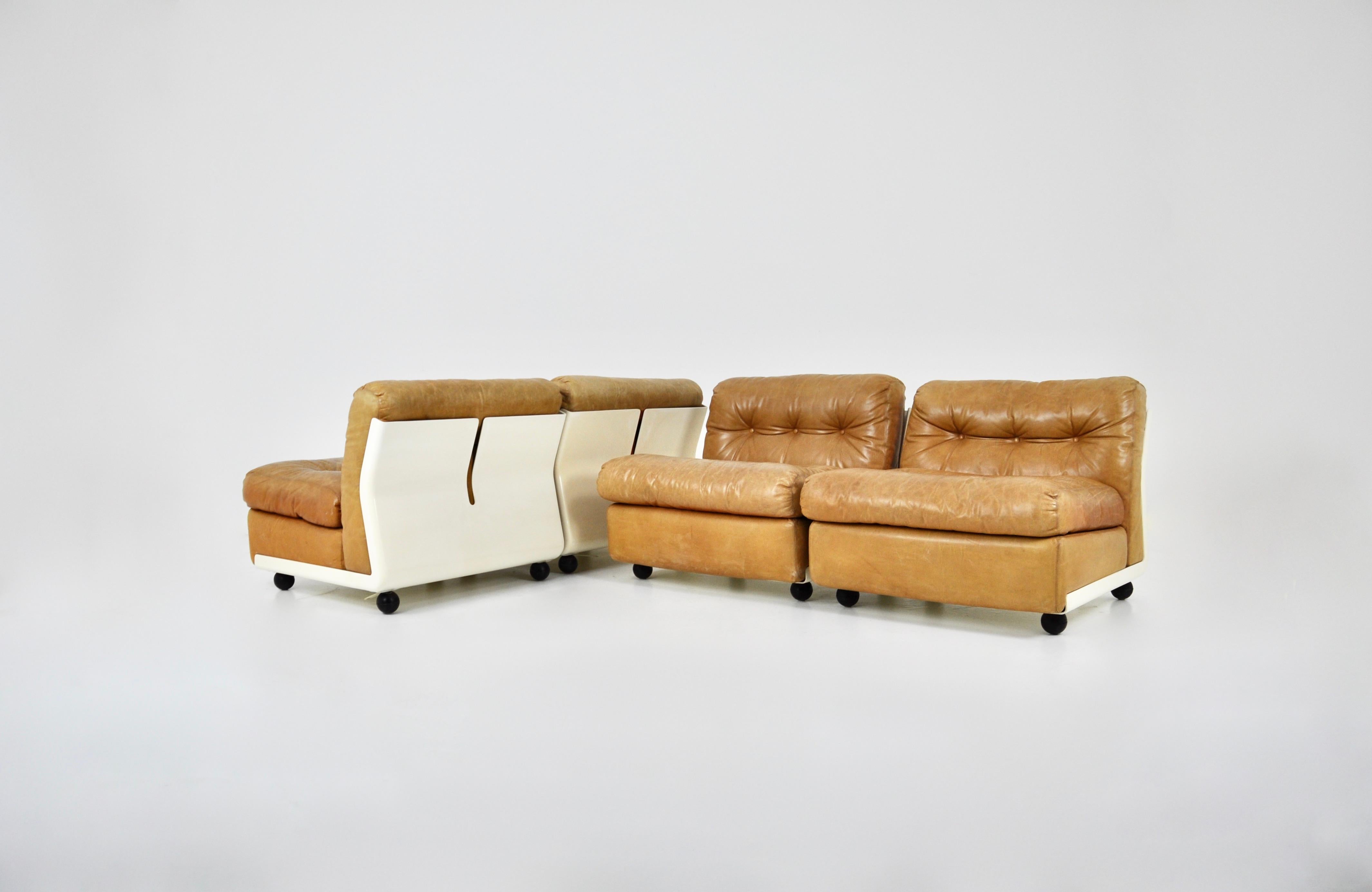 Set of 4 brown leather armchairs with fibreglass shell. Designed by Mario Bellini for C&B Italia. Seat height: 43 cm. Stamped C&B Italia. They can be attached together. Wear due to time and age.
