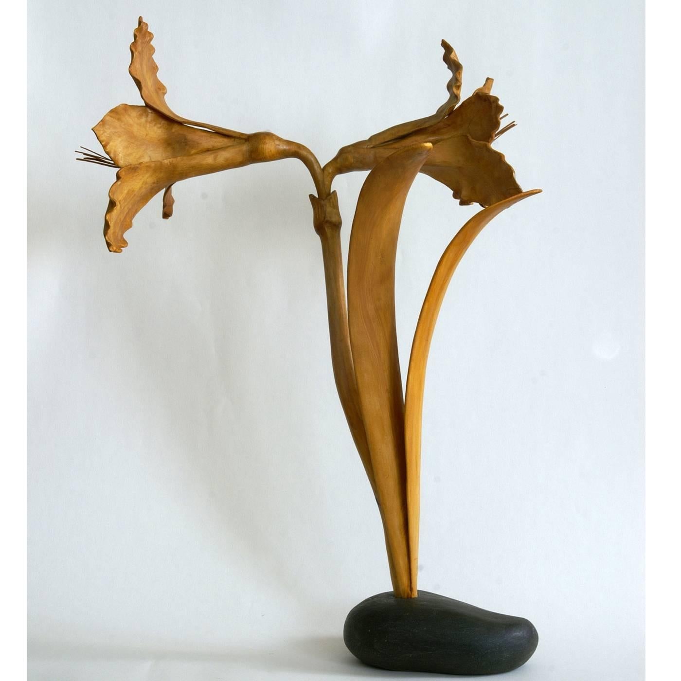 This delicate sculpture of an Amaryllis flower in bloom is entirely hand-carved in Swiss pinewood, painted by hand using natural pigments, and then lacquered for a glossy finish. The Swiss pine wood base is hand-carved into the shape of a stone and