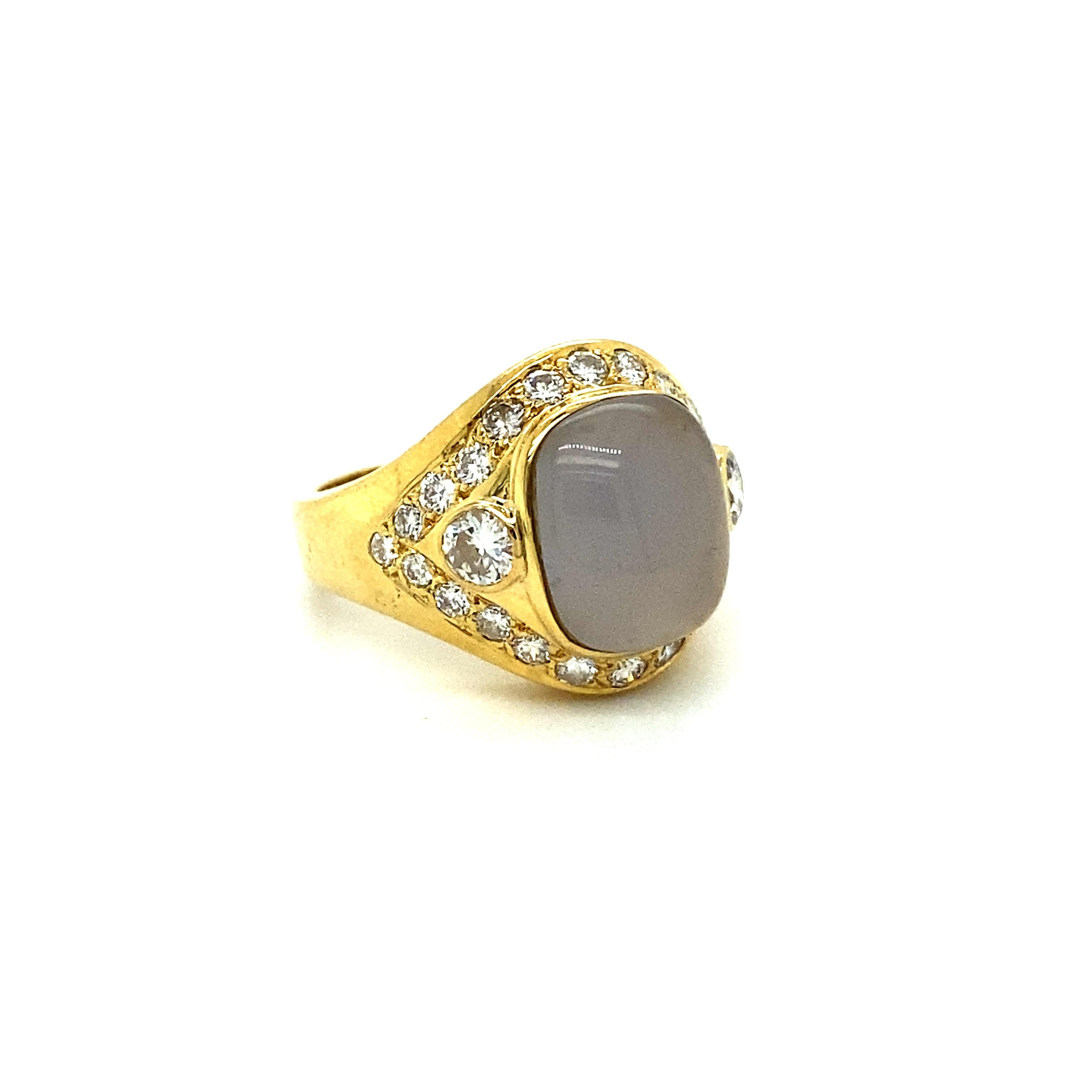 This Amazing Chalcedony and Diamond Engagement Ring is a truly special, one of a kind piece. Crafted in 18K Yellow Gold, the design features a central Bezel Set Cabochon Cut, Cushion Shaped, Light Greyish/Blue Chalcedony, flanked on each side by a