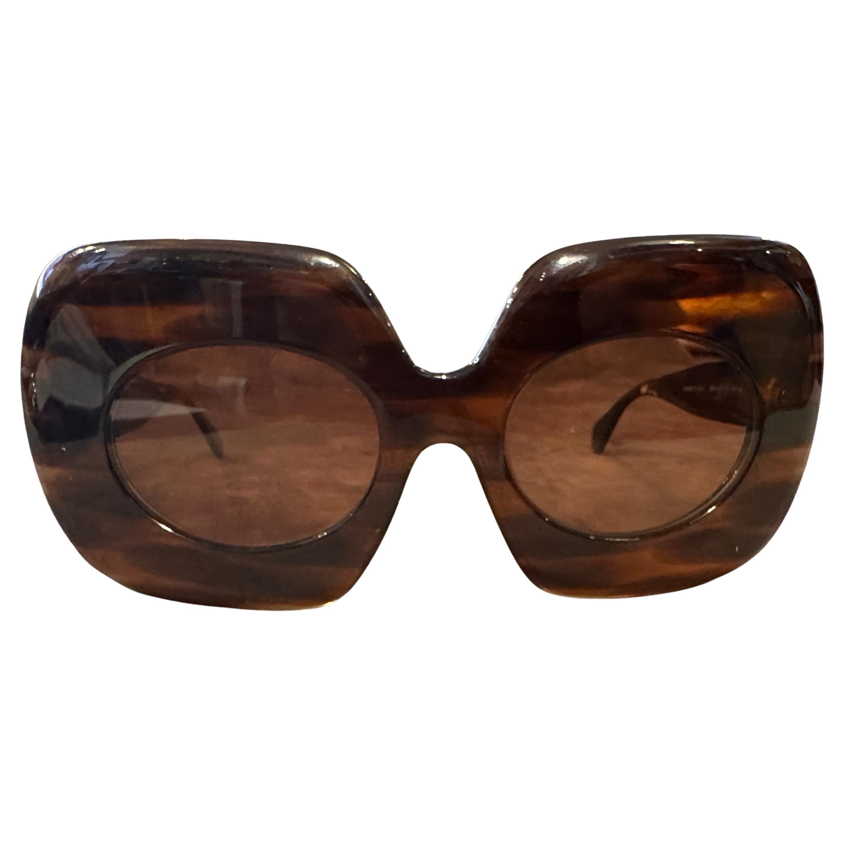 These 1960s oversized tortoiseshell French sunglasses by Shysseidon Lunettes are a bold, retro-chic accessory emblematic of the decade’s flair for drama and glamour.: The exaggerated, butterfly-shaped silhouette with rounded lenses is a striking nod