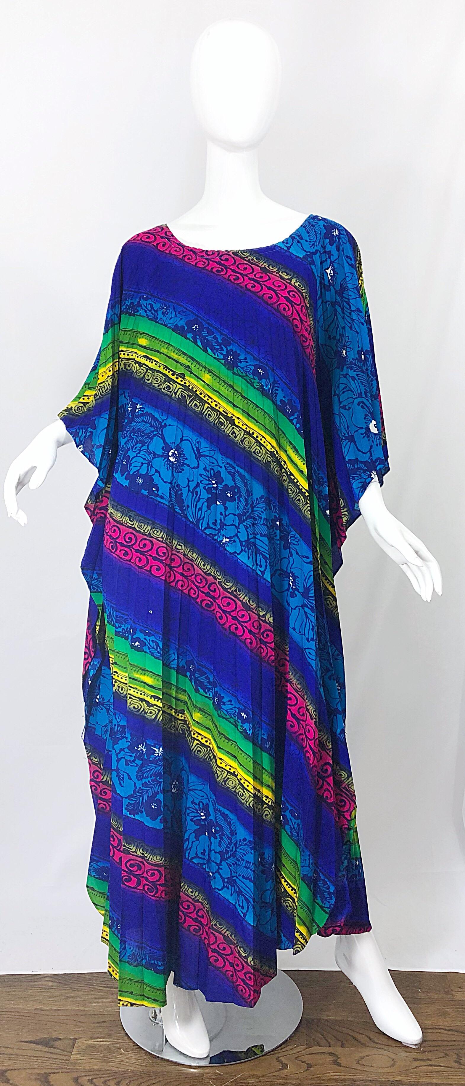 Superbe robe maxi caftan en coton plissé aux couleurs vives des années 970 ! Il présente un plissage en accordéon avec des fleurs imprimées sur toute la surface. Il suffit de glisser sur la tête. 
En très bon état
S'adapte à toutes les tailles